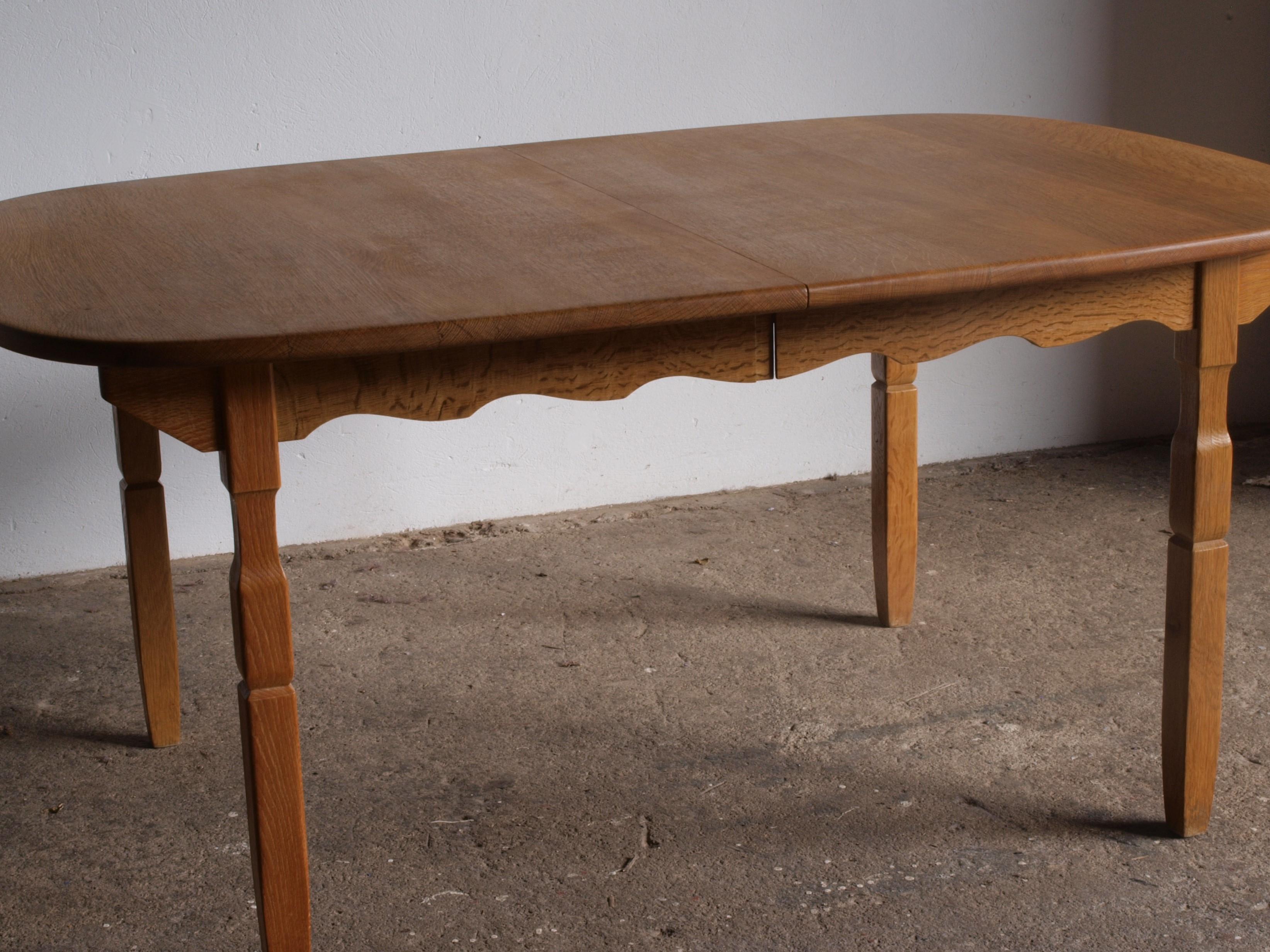 This vintage oak table shares the essence of Kjaernulf's furniture design. Its brutalist aesthetic, highlighted by intricate leg carvings, is beautifully balanced by its rounded shape. In excellent condition and gliding smoothly, it exudes