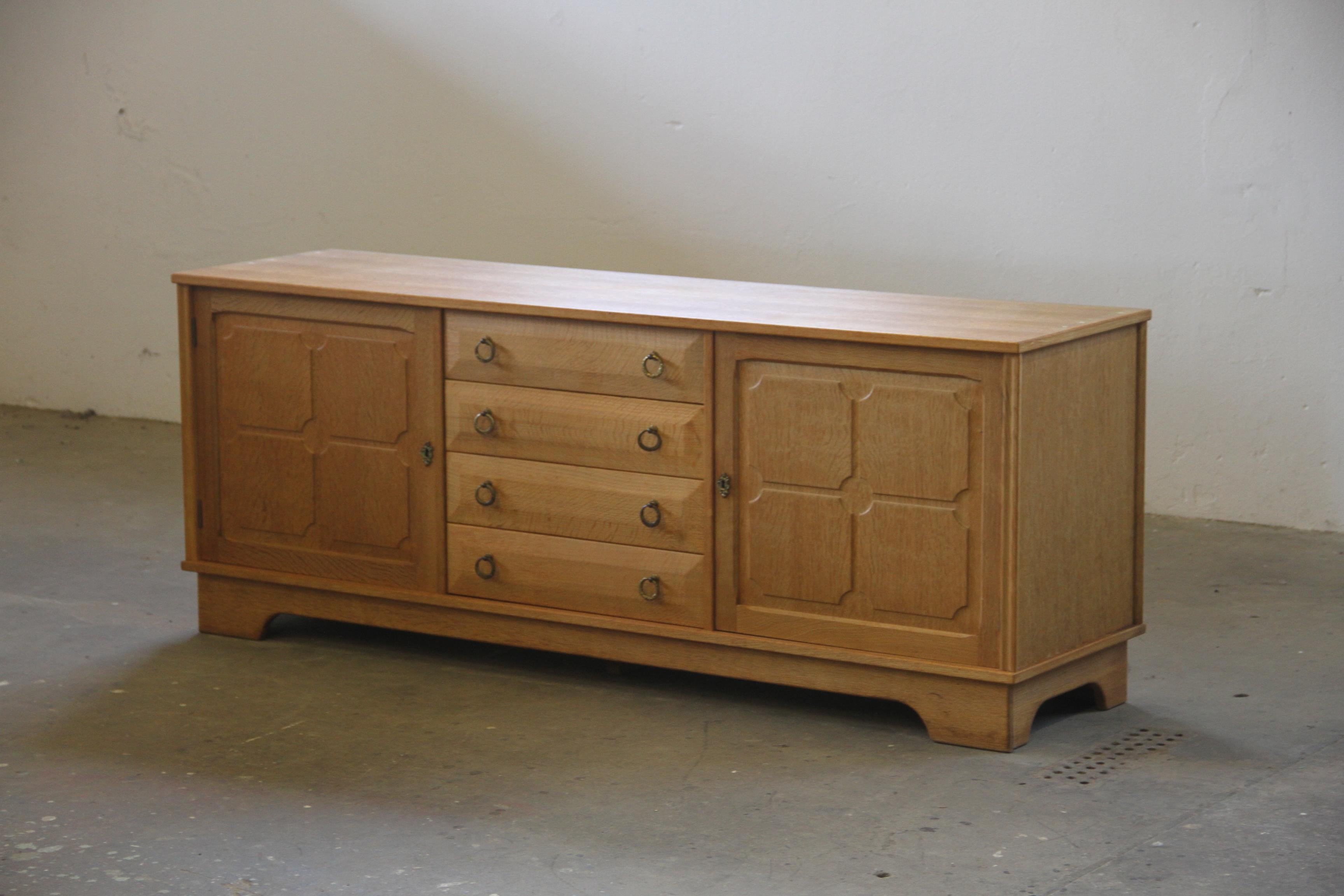 A Danish Mid-Century Modern low sideboard in Nordic oak, designed and crafted in Denmark. Often attributed to Henning (or Henry) Kjærnulf, this piece embodies Scandinavian Modern aesthetics with a distinctive 
