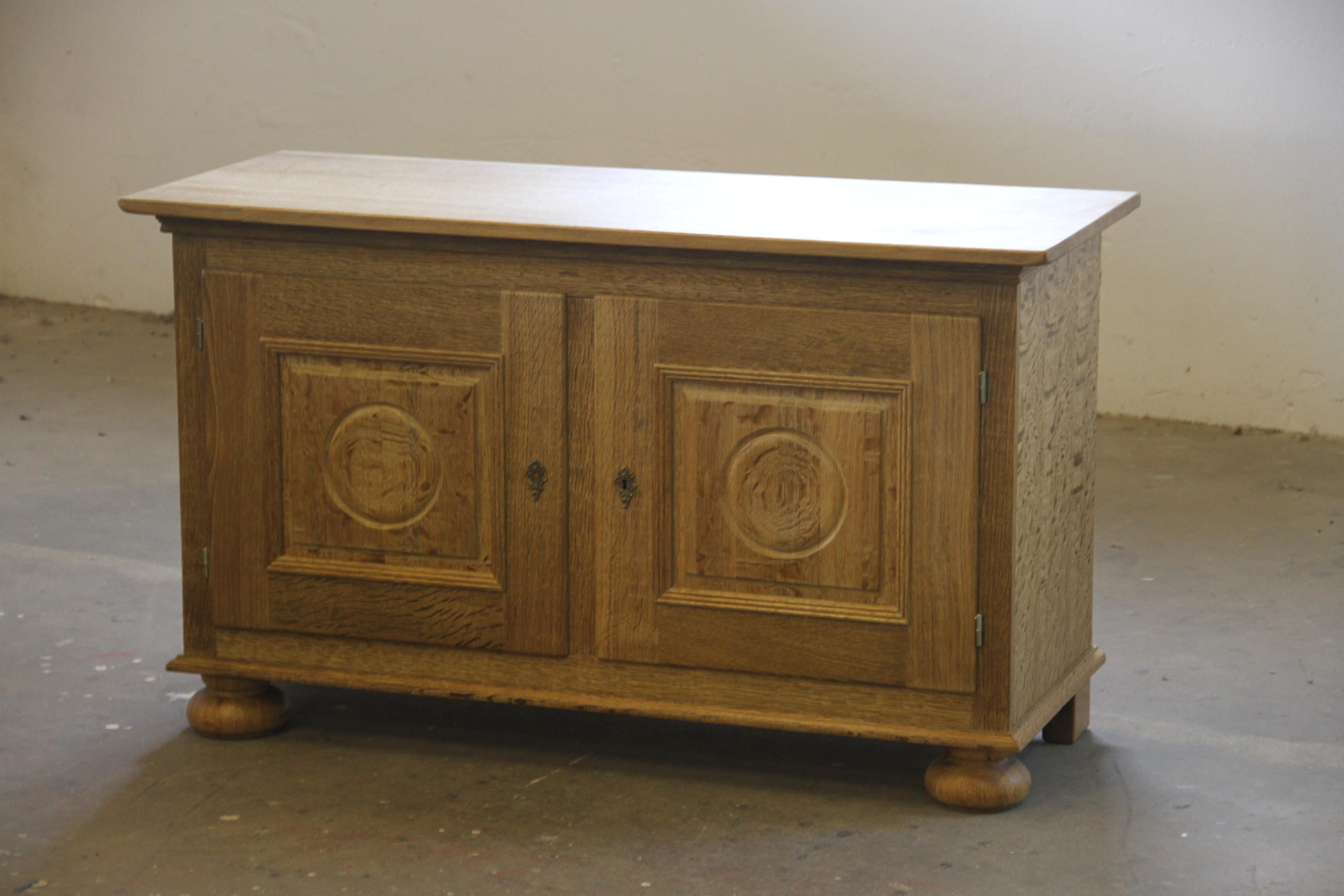 A Danish Mid-Century Modern low sideboard in Nordic oak, designed and crafted in Denmark. Often attributed to Henning (or Henry) Kjærnulf, this piece embodies Scandinavian Modern aesthetics with a distinctive 