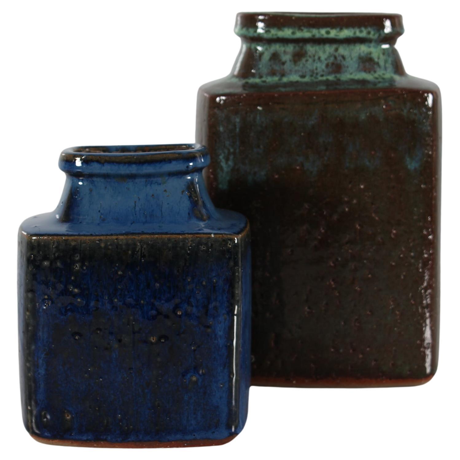 Pair of mid-century Danish brutalist style square vases by ceramist and artist Jytte Trebbien handmade in the 1970´s. 
The rustic vases are made of chamotte clay which gives a rough and vivid surface. The large vase has a glossy greenish-brown