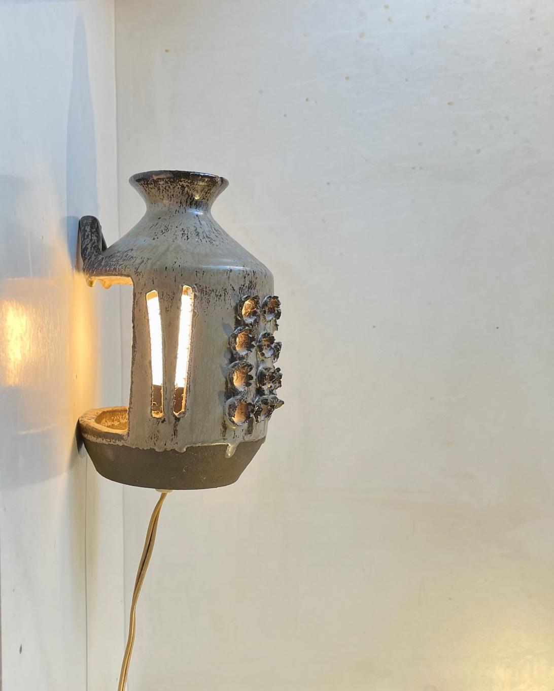 Unusual vase shaped wall sconce with deconstructed brutalist styling and hares-fur glaze. Studio made at Stentøj Denmark circa 1970 in a style reminiscent of Søholm and Kingo. Measurements: H: 19 cm, W: 13 cm, Dept: 13 cm. 

For the US. It will