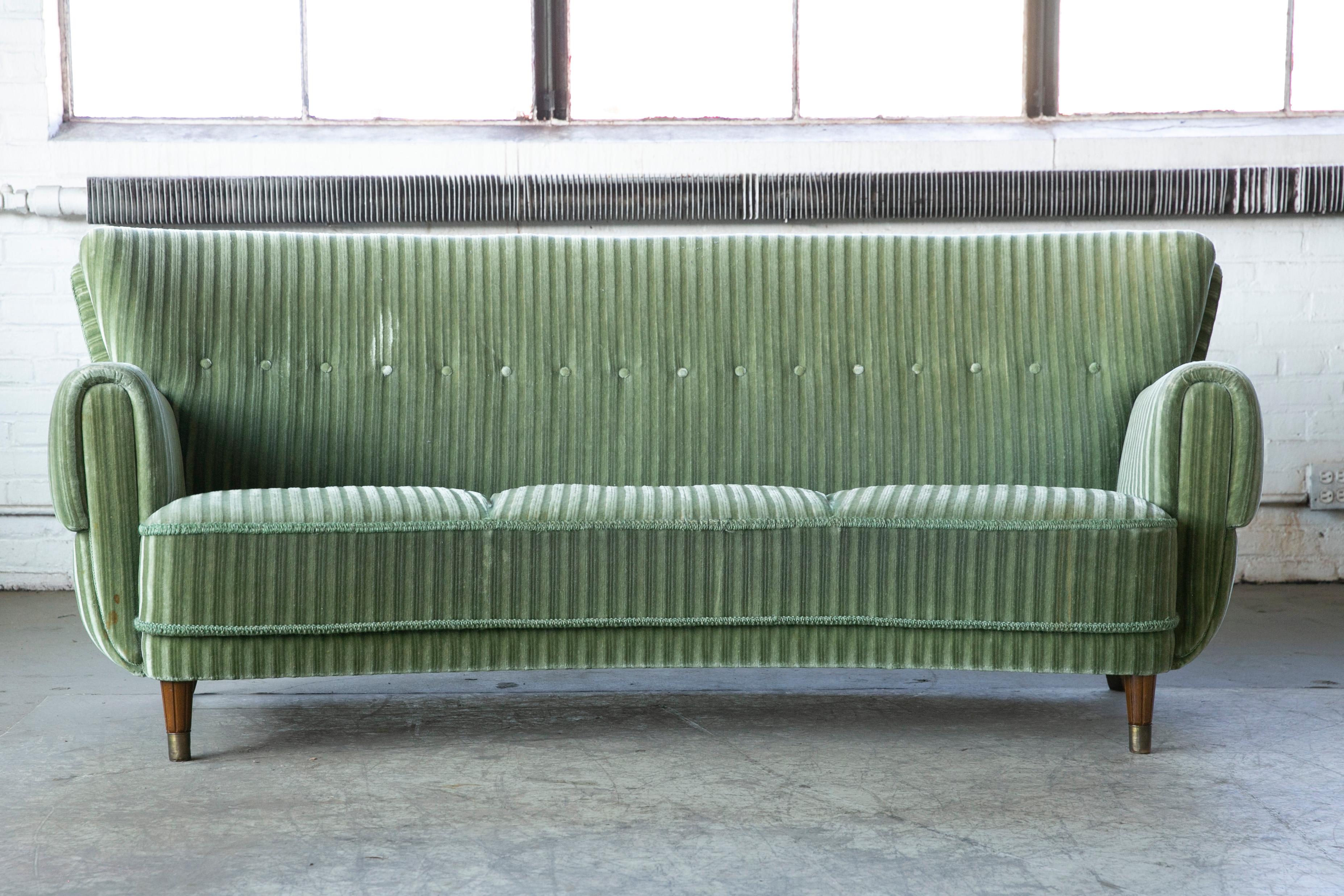 Beautiful and very elegant late 1940s to early 1950's curved three-seat sofa in green mohair wool fabric. The sofa has springs in the seat and the backrest and the cushions are nice and firm and the sofa solid sturdy. The original mohair fabric is