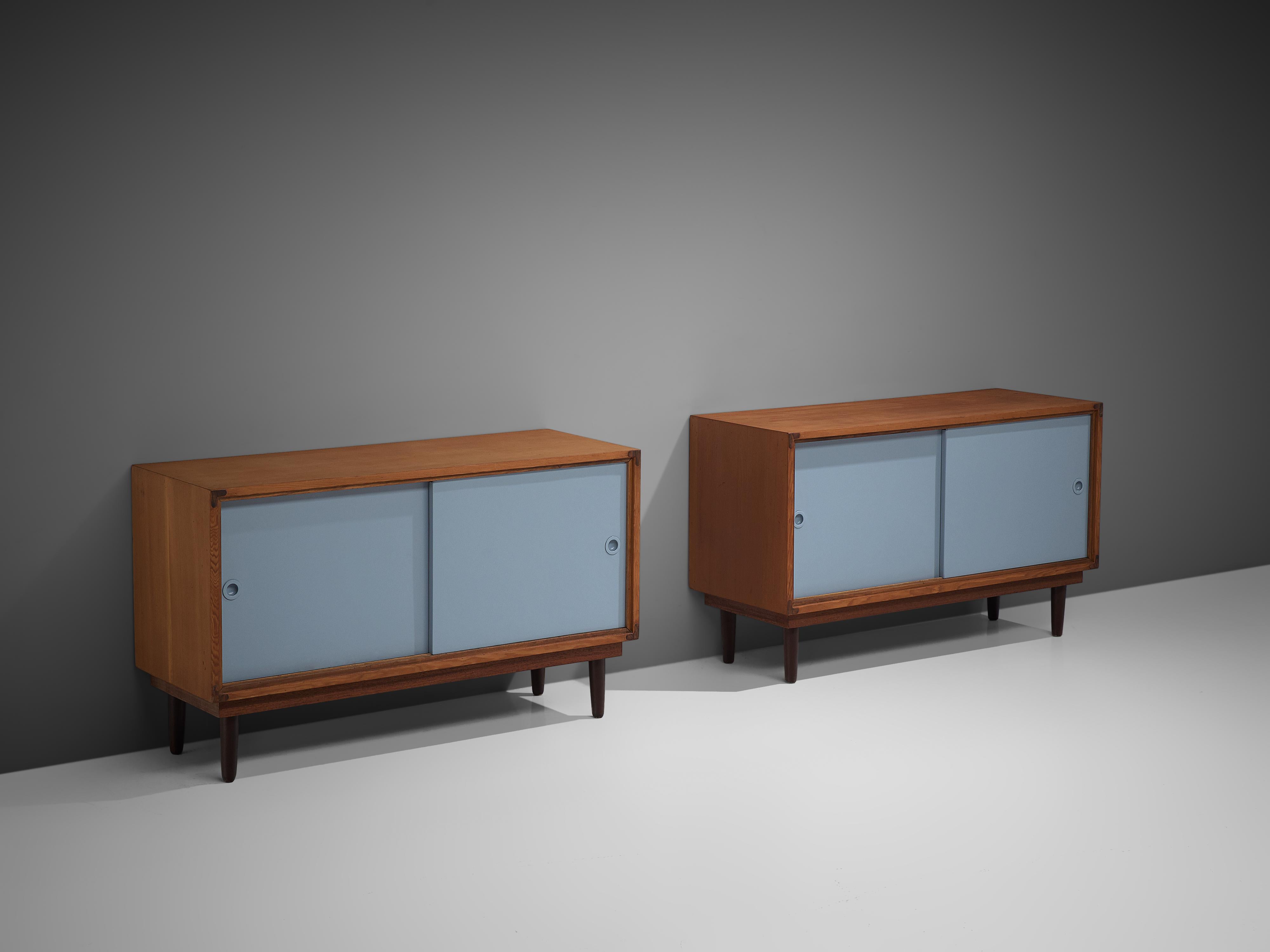 Cabinets, solid pine, lacquered wood, Denmark, 1950s

These cabinets embody a simplistic design, with a rectangular front placed on tapered round legs. The warm expression of the wood nicely combines with the soft blue sliding doors. With the subtle