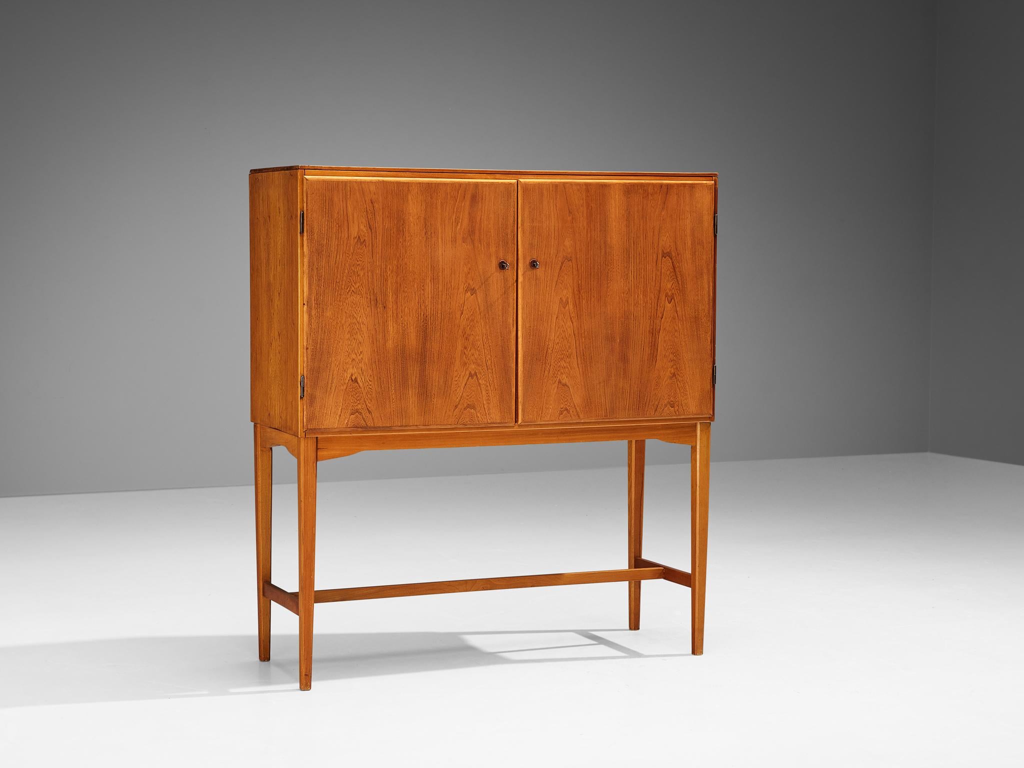 Cabinet, teak, beech, Denmark, late 1940s. 

Excellent Danish cabinet executed in beautiful teak that shows a dynamic grain pattern. An open exterior is realised with the ‘cabinet-on-stand’ feature that is based on English and Asian cabinets