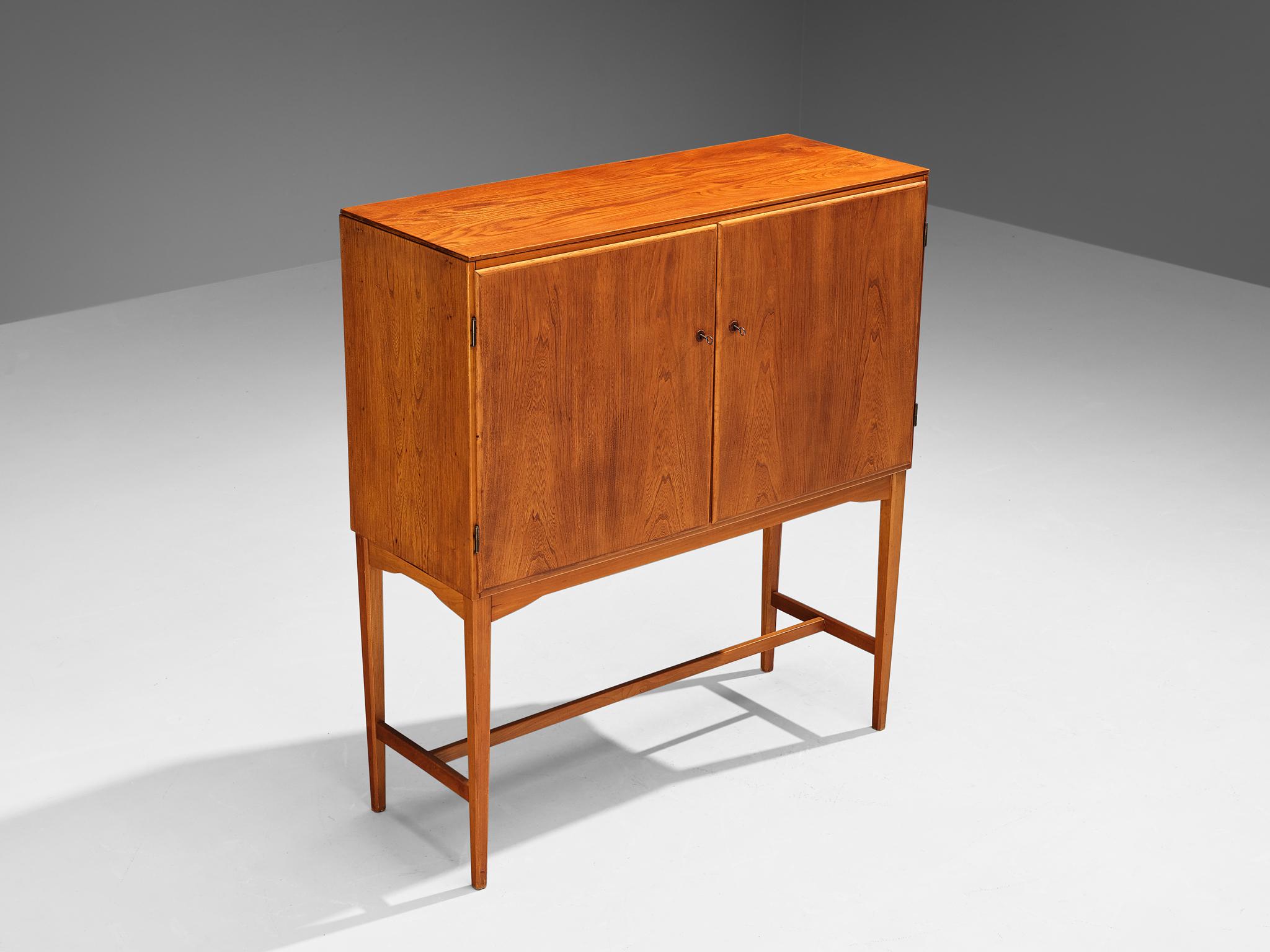 Cabinet, teak, beech, Denmark, late 1940s. 

Excellent Danish cabinet executed in beautiful teak that shows a dynamic grain pattern. An open exterior is realised with the ‘cabinet-on-stand’ feature that is based on English and Asian cabinets