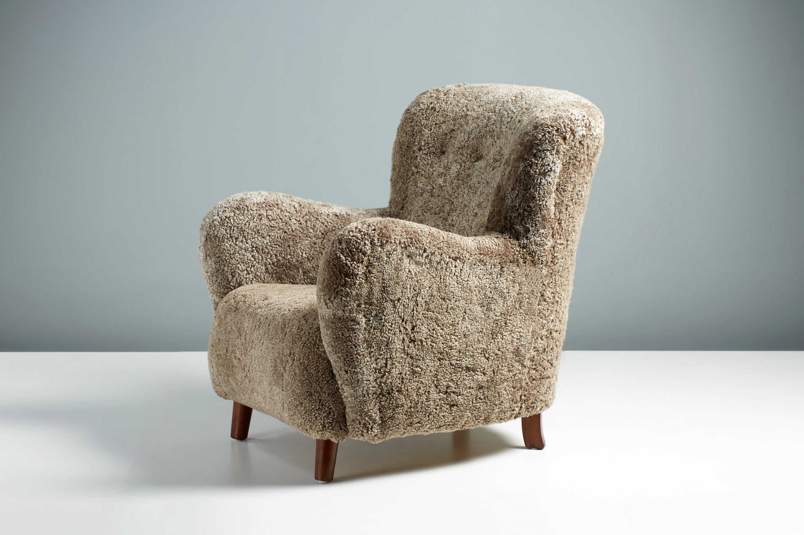 Danish Cabinetmaker Sheepskin Armchair, c1940s.

This lounge chair produced by a Danish Cabinetmaker in the 1940s and is typical of Danish lounge chair designs of the day. It features a curved wing-back with stained beech legs. The chair has been
