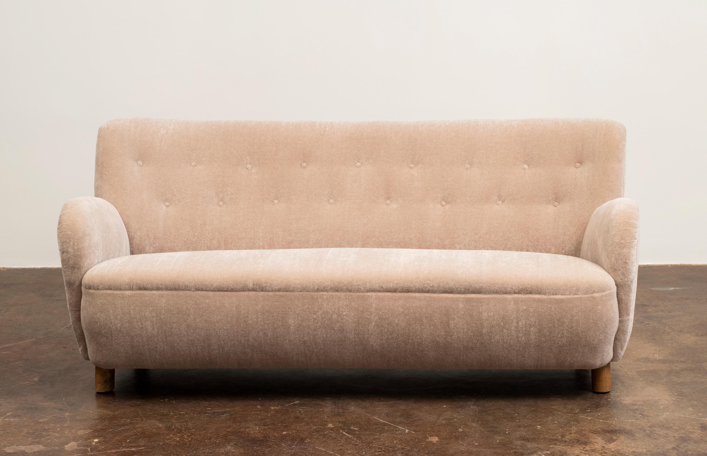A Danish cabinet maker's sofa recently reupholstered in a lush champagne mohair velvet by Leo Schellens with button-fitted back and graceful, curved arms. Denmark, 1940s.