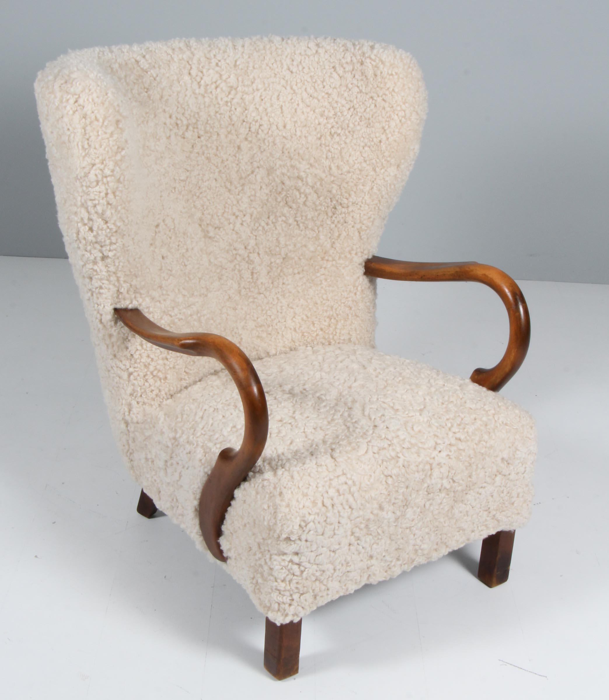 Danish cabinetmaker lounge chair new upholstered with lambskin.

Legs of stained beech.

Made in the 1940s.