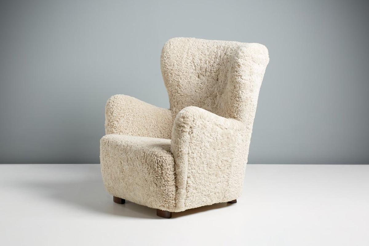 Danish Cabinetmaker Sheepskin Armchair, circa 1940s.

This tall Lounge chair produced by a Danish Cabinetmaker in the 1940s and is typical of Danish lounge chair designs of the day. It features a curved wing-back with stained beech legs. The chair