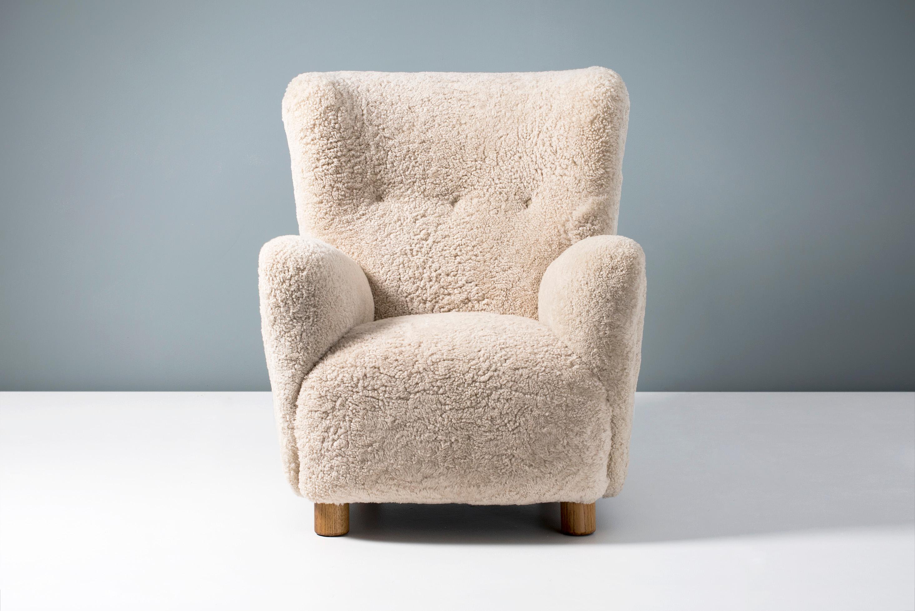 High-backed vintage armchair in the manner of Flemming Lassen, produced in Denmark sometime between 1940-1950. The legs are made of European oak and the chair has been completely reconditioned in our London workshop with new upholstery in luxurious