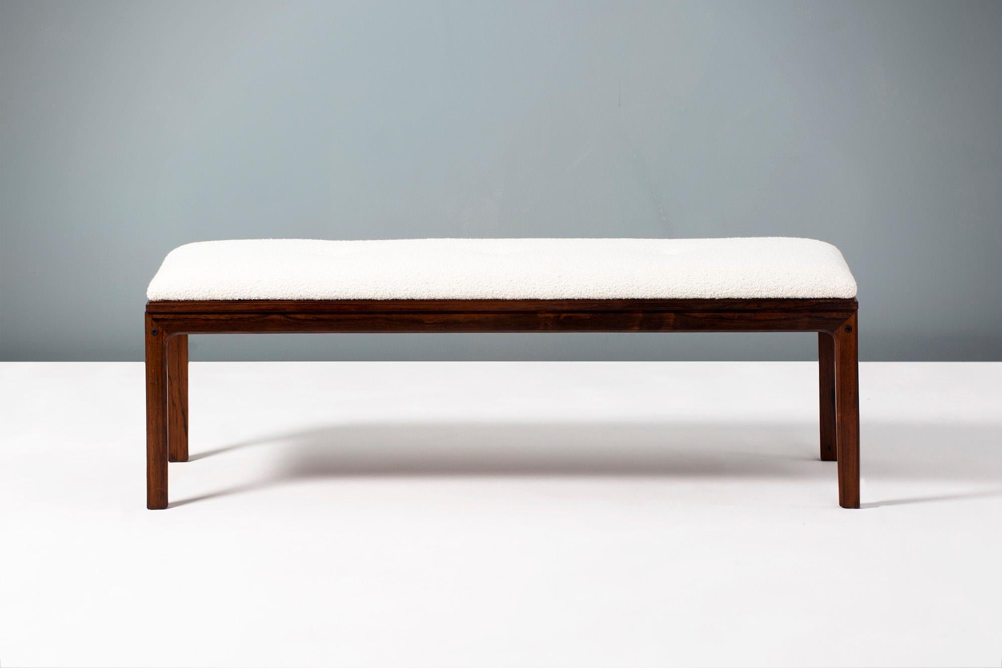 Danish cabinetmaker produced bench with stunning, exotic grain rosewood frame. The top is upholstered in new cotton-wool blended boucle fabric with 3 shallow buttons. Produced in the 1960s in Denmark. 

The perfect piece for a hallway or the end