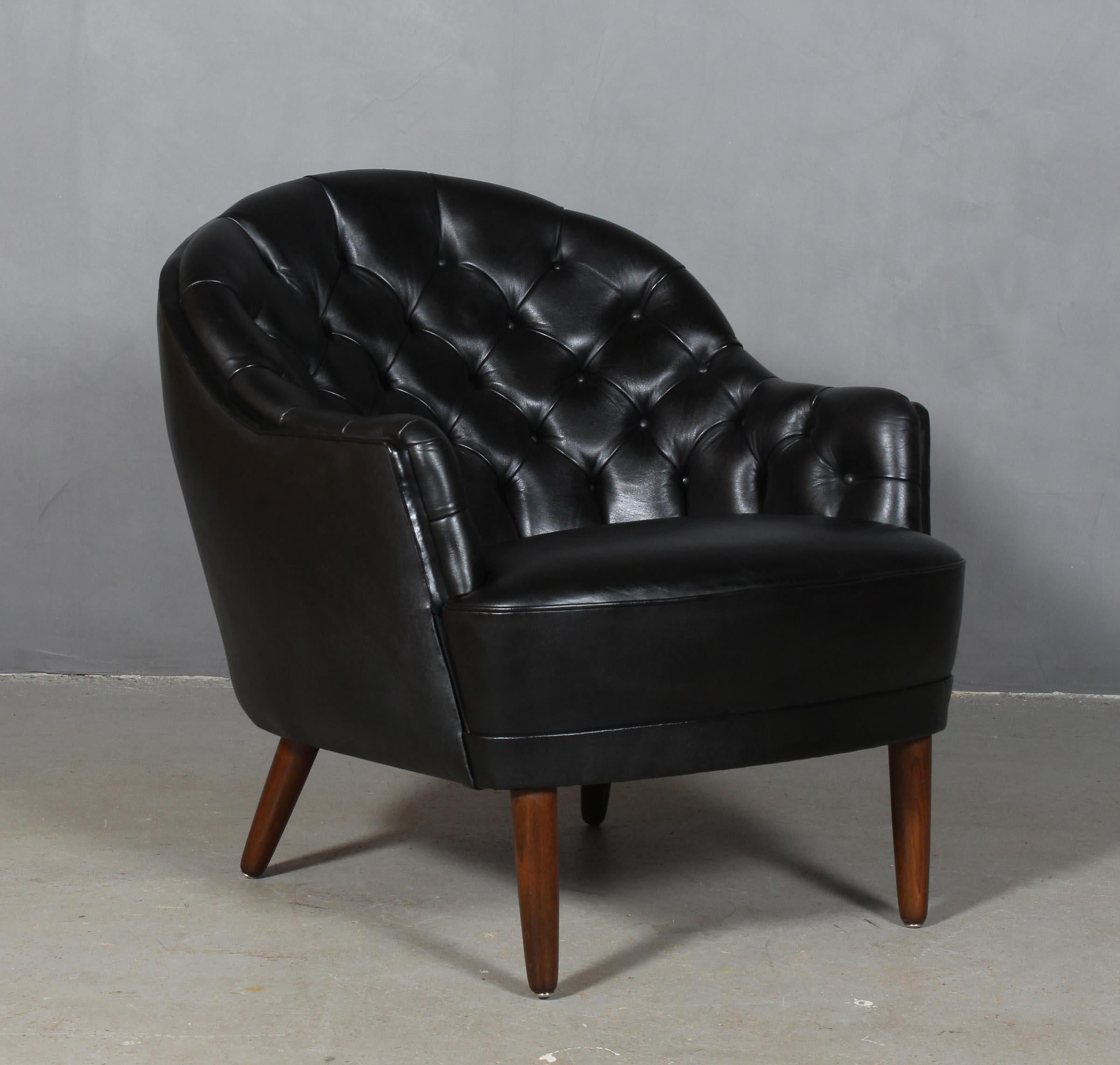 Danish cabinetmaker club chair in original black patinated leather.

With buttons.

Legs of stained beech.

Made in the 1940s.