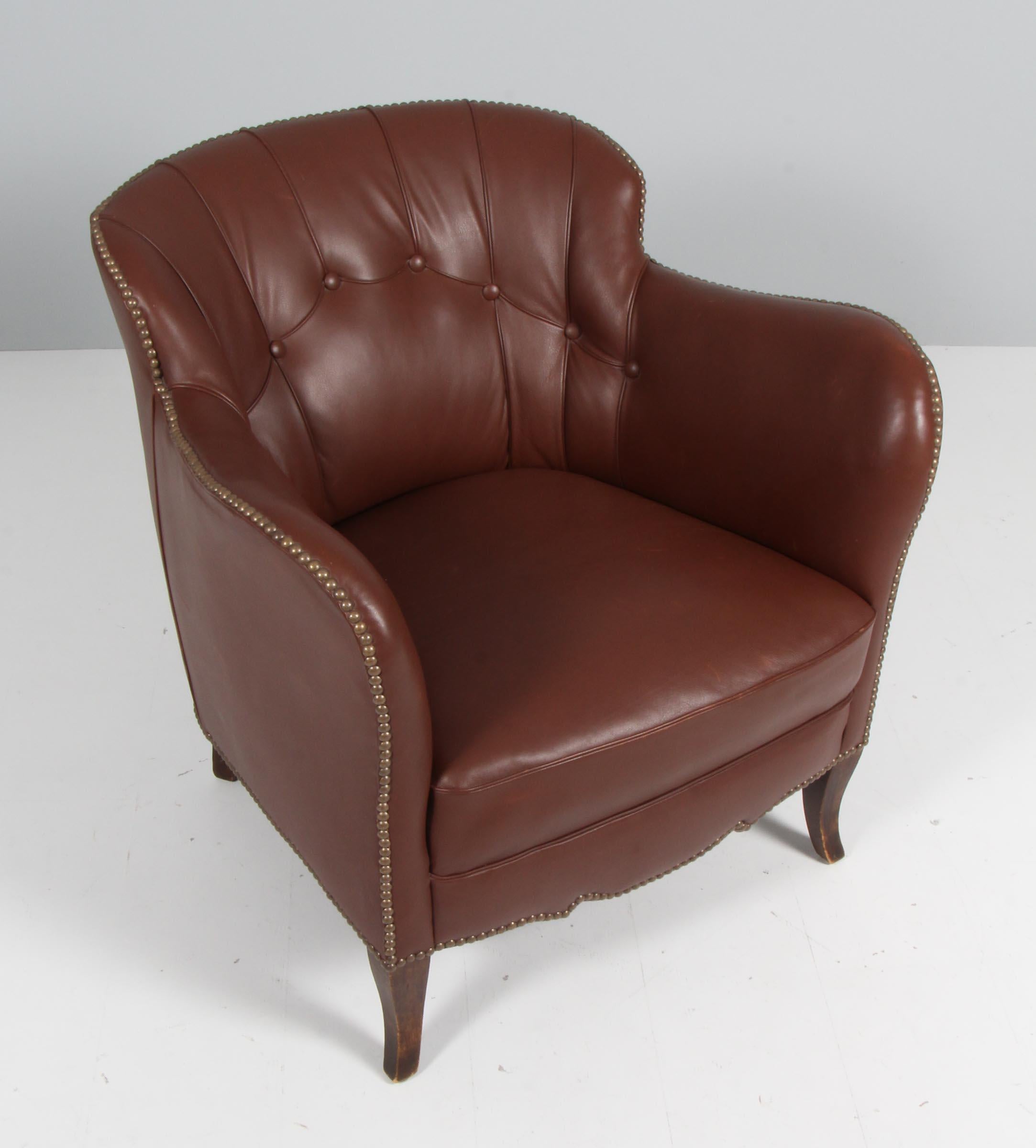 Danish cabinetmaker club chair in original brown patinated leather.

Legs of stained beech.

Made in the 1940s.