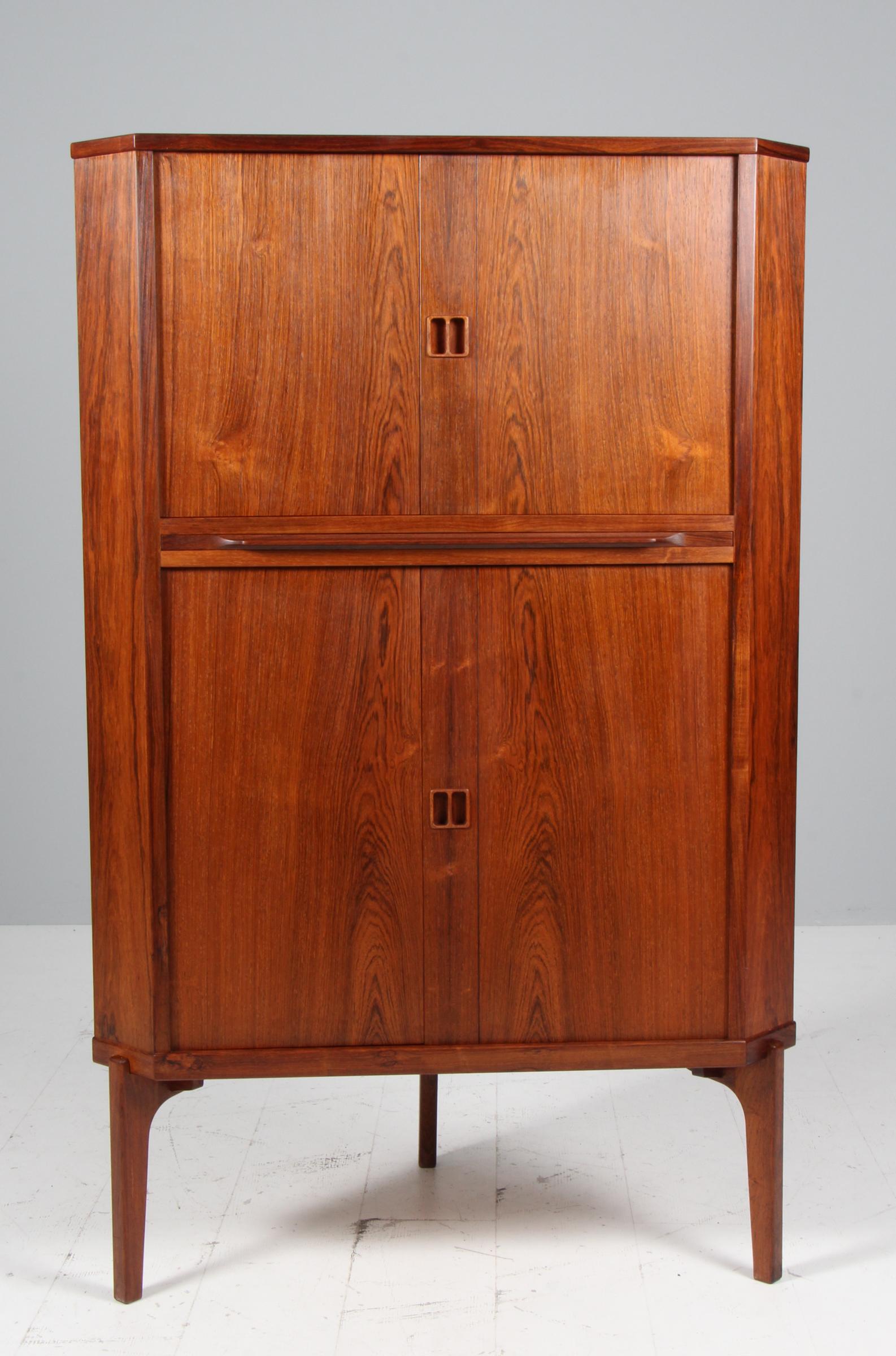 Ebanista danese, mobile ad angolo in palissandro. Con due ante dove dietro ci sono dei ripiani. Sotto le porte due vassoi. 
Realizzato negli anni '60.