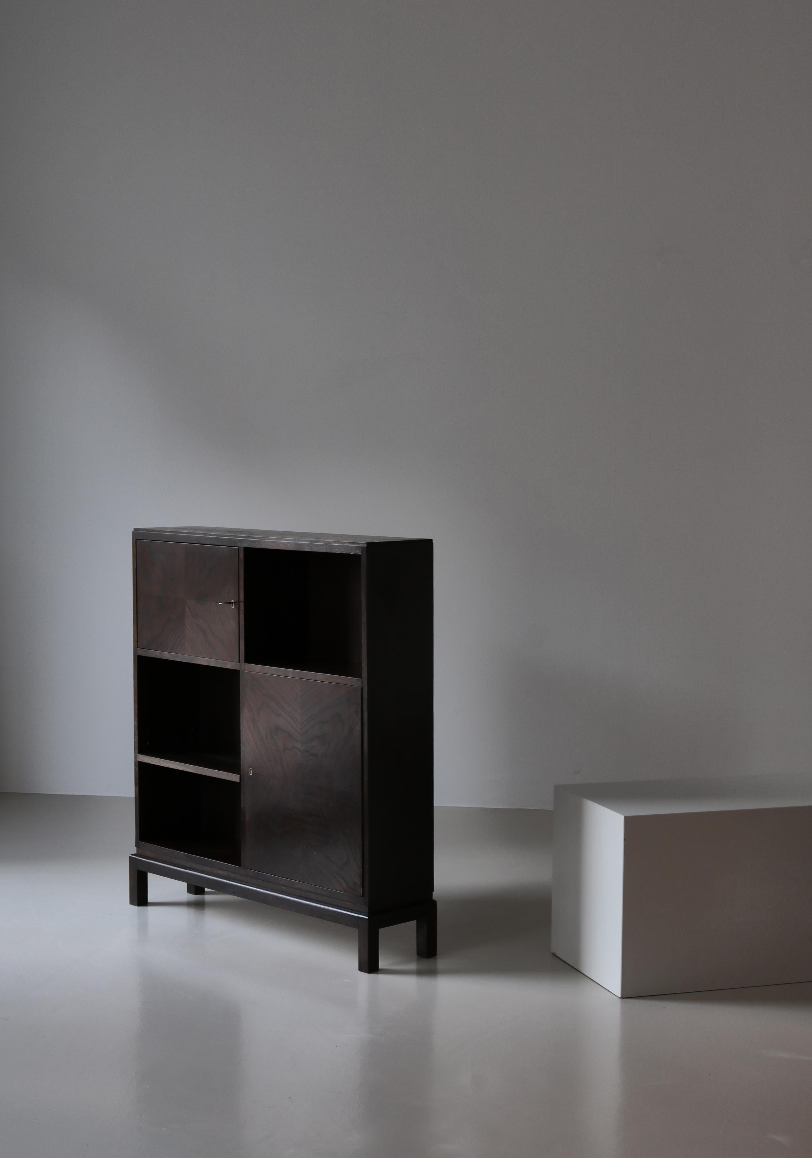 Charmante armoire fabriquée au Danemark en 1930 par un ébéniste inconnu. L'extérieur des armoires est en chêne patiné foncé et l'intérieur en bois de pin chaud. Le style est typique de l'adaptation danoise du style fonctionnaliste Bauhaus, qui était