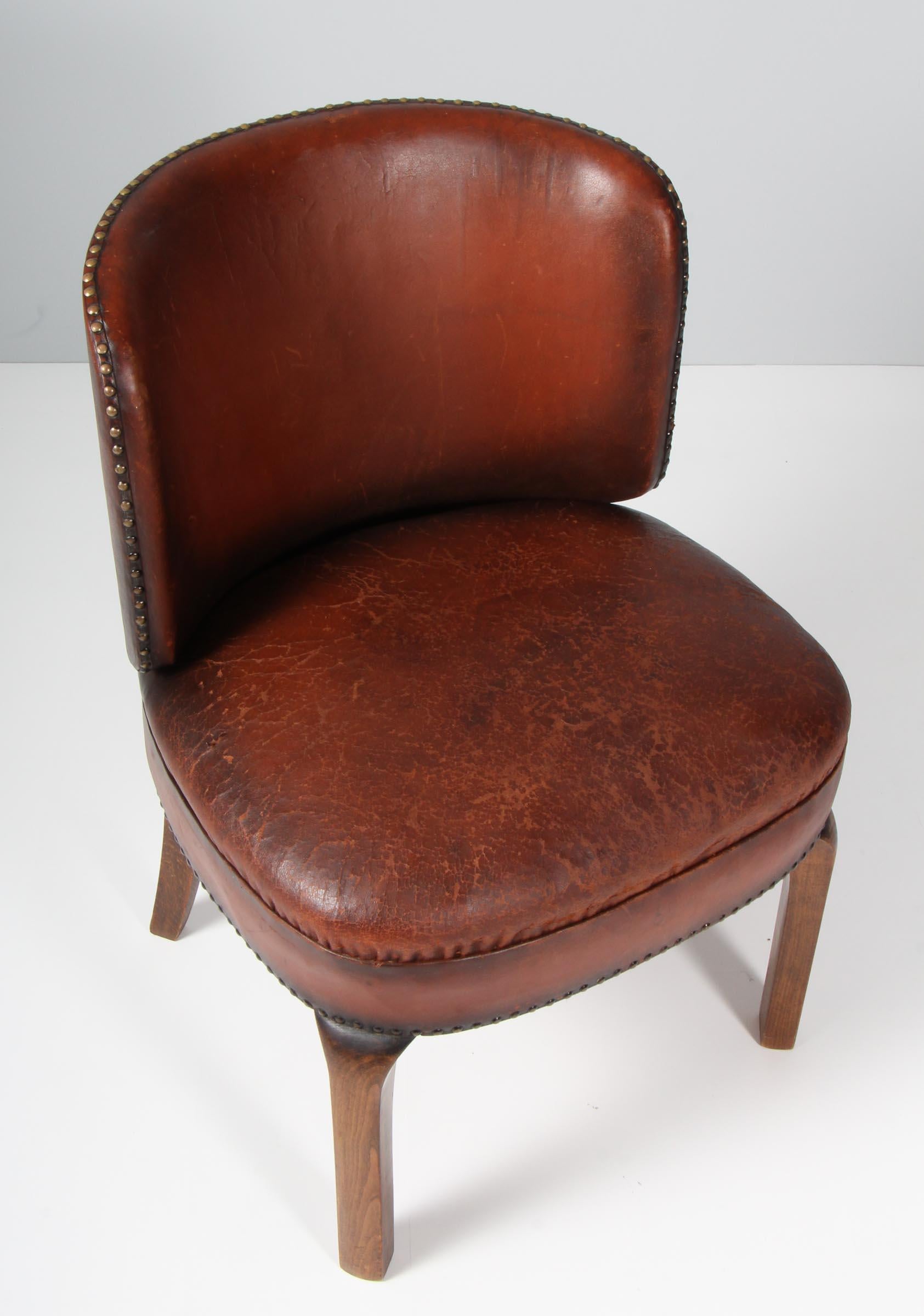 Danish cabinetmaker lounge chair from the 1930s, with original patinated leather. Legs of stained wood.