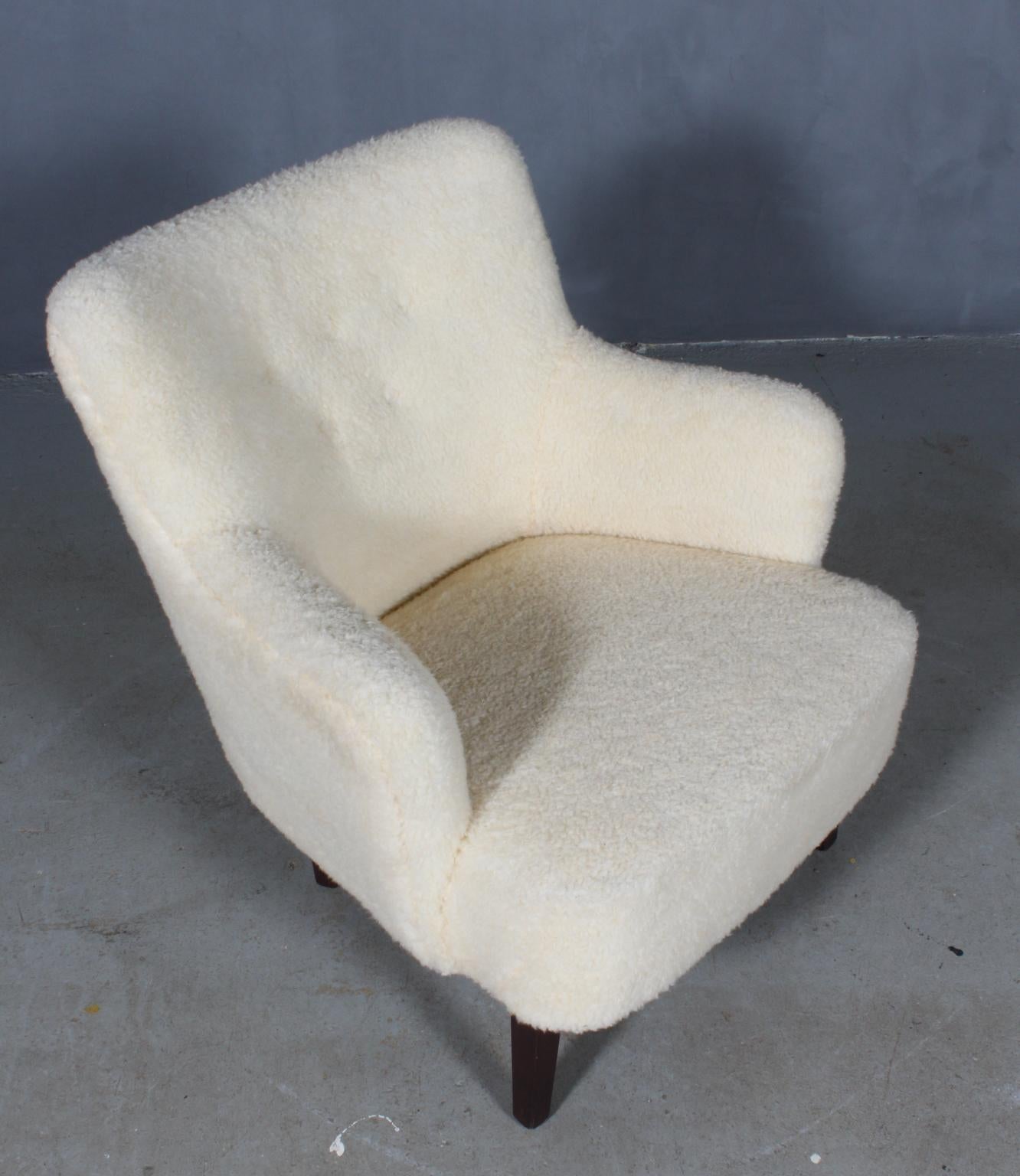 Danish cabinetmaker lounge chair upholstered with artificial sheepskin.

Legs of stained beech.

Made in the 1940s.