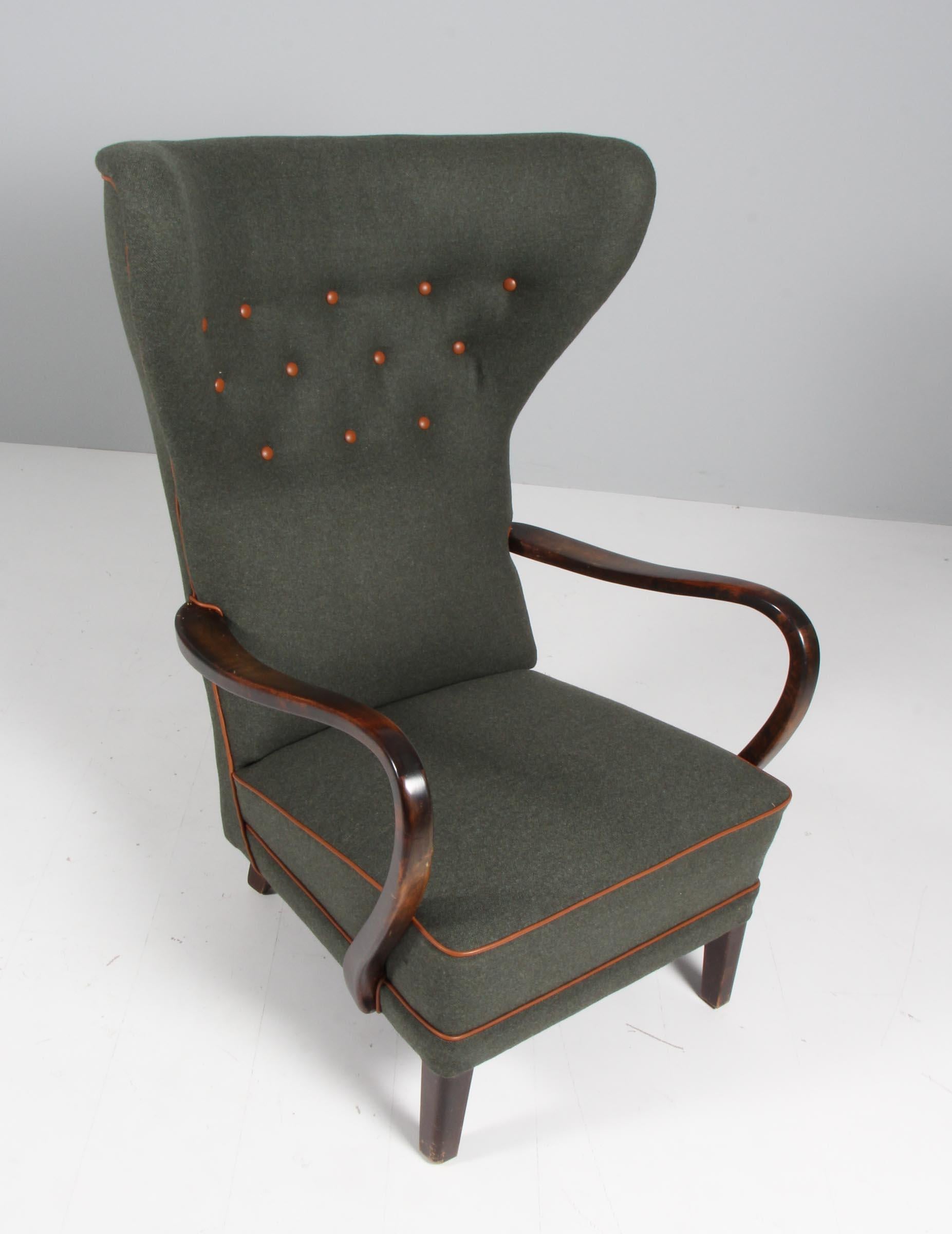 Danish cabinetmaker lounge chair / wingback new upholstered with green wool and cognac aniline buttons and tubing.

Legs and armrests of stained beech.