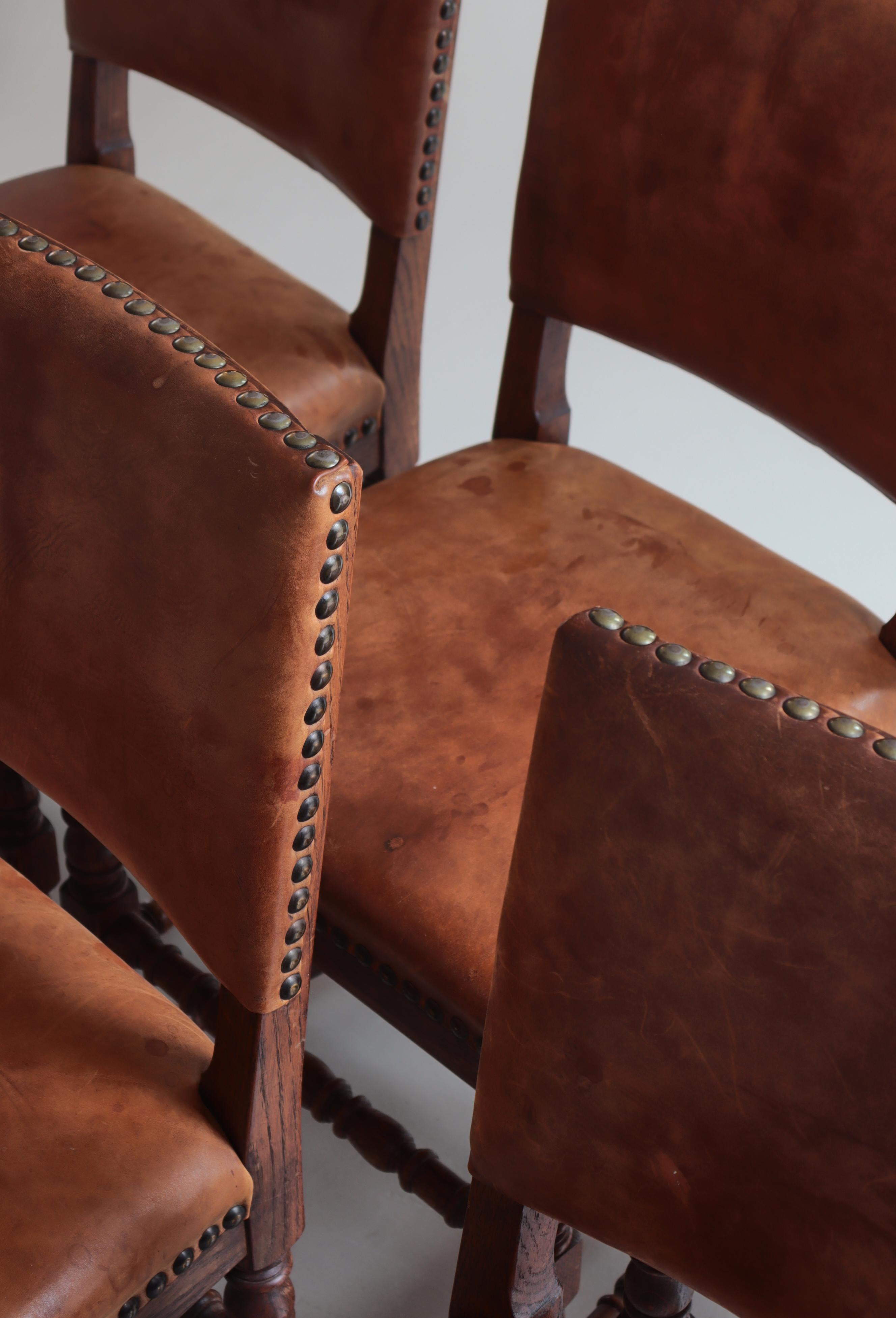 Wonderful set of 6 dining chairs by a Danish Cabinetmaker made in the 1940s. Patinated dark oak and original upholstery in natural leather and brass nails. Very comfortable due to the spring coil seats and soft leather on seats and back.