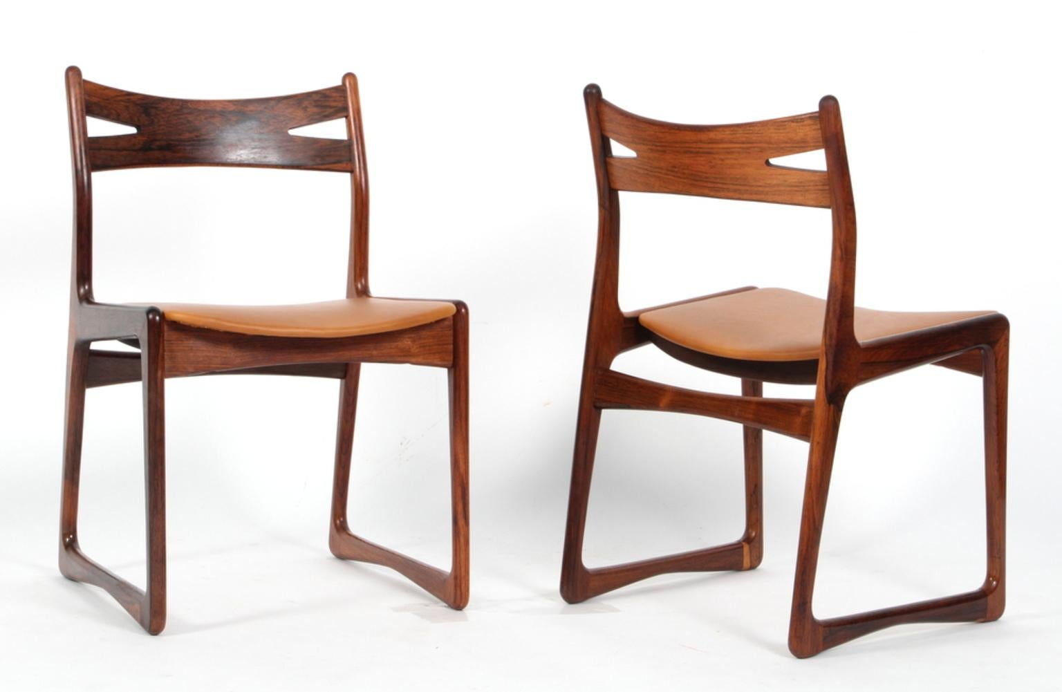 Danish cabinetmaker set of eight dining chairs new upholstered with silk aniline leather.

Frame of partly massive rosewood.

Backrest in style of Hans Wegner's Savbuk.