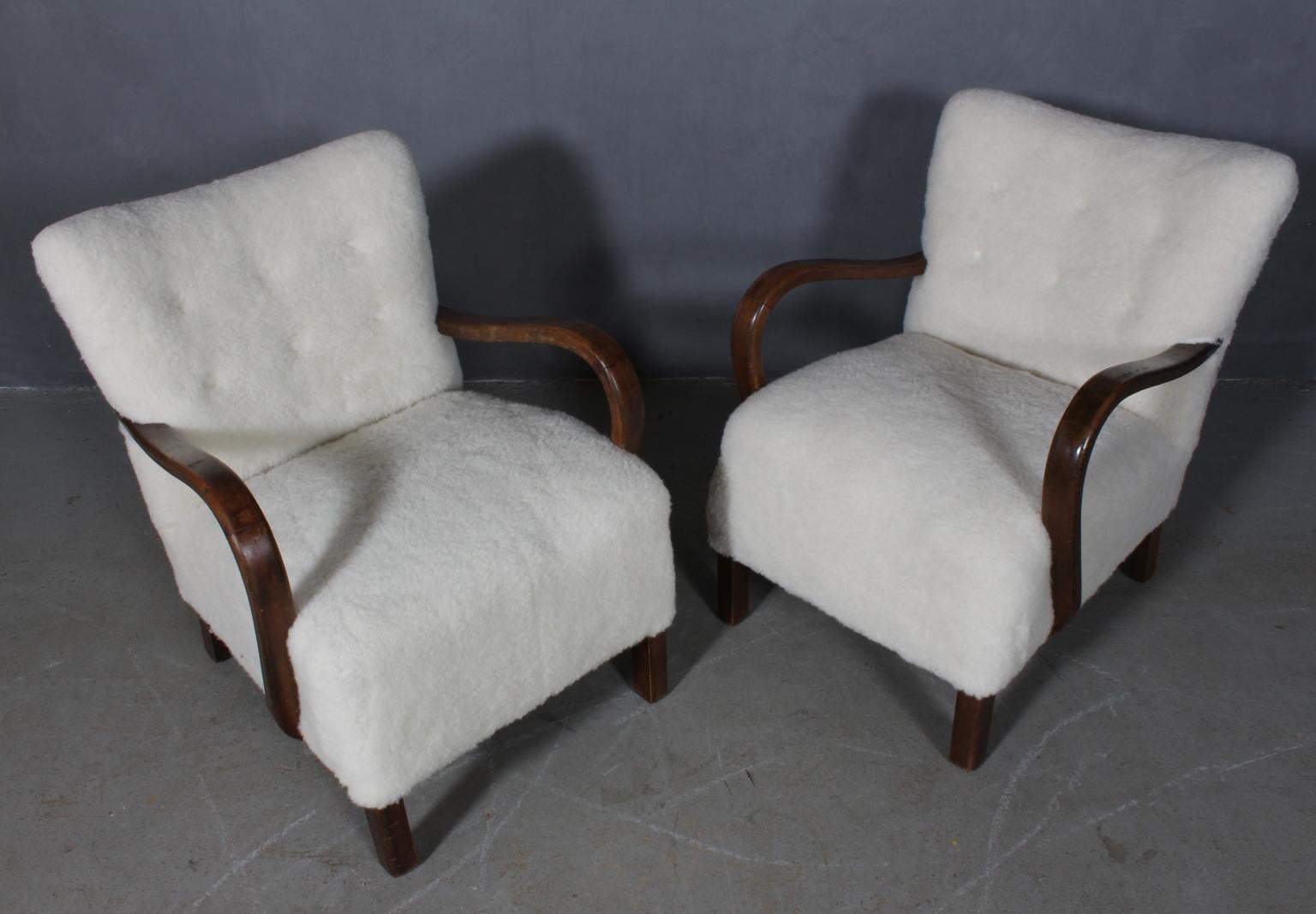 Danish cabinetmaker set of lounge chairs new upholstered with lambwool.

Legs and armrests of stained beech.

Made in the 1940s.

  