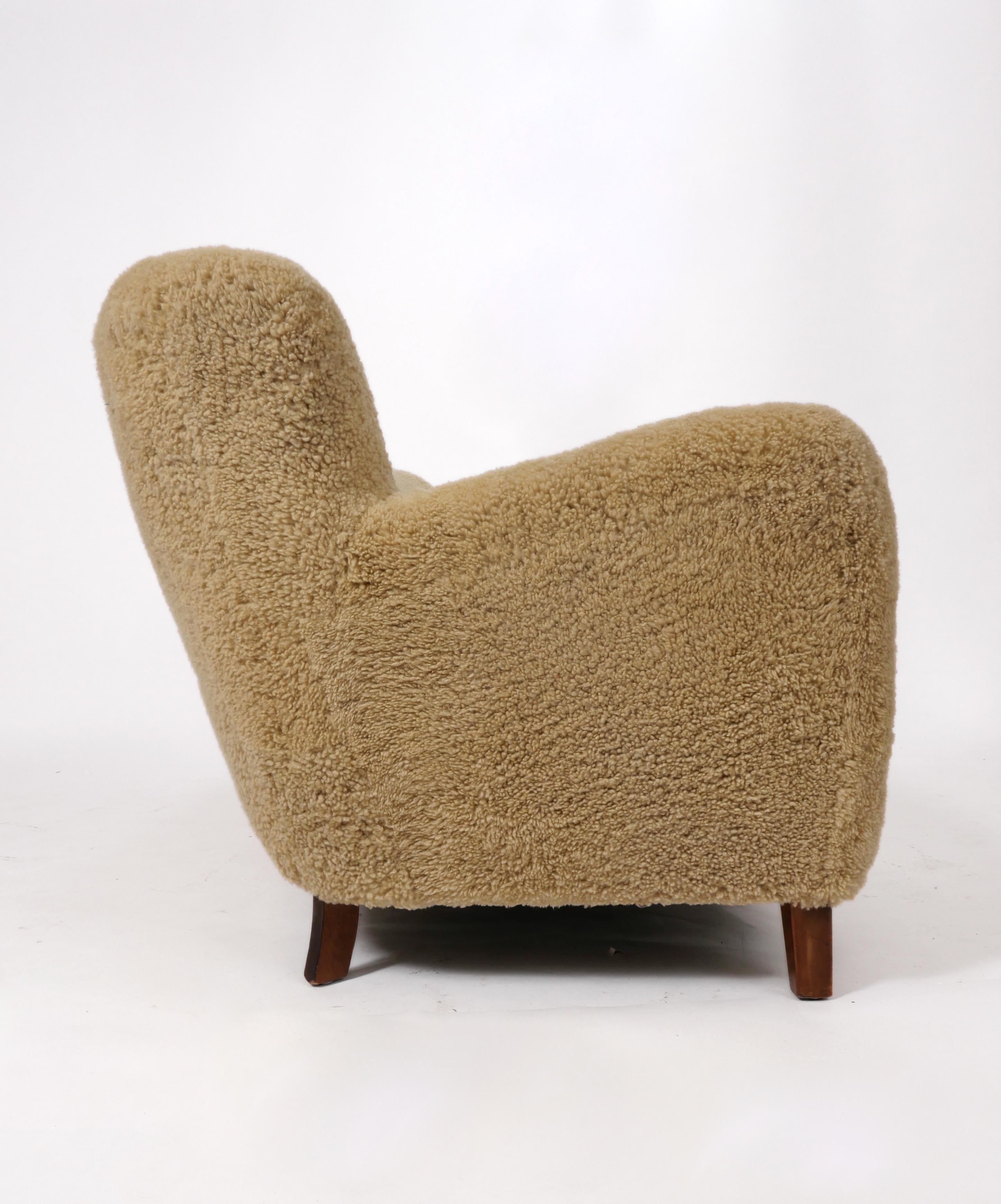 A classic silhouette; circa 1940s-40s Danish Cabinetmaker sofa, freshly upholstered in wonderful natural sheepskin. Buttons at back are done in cognac full-grain leather- which provides a subtle contrast and pairs nicely with the legs, which are