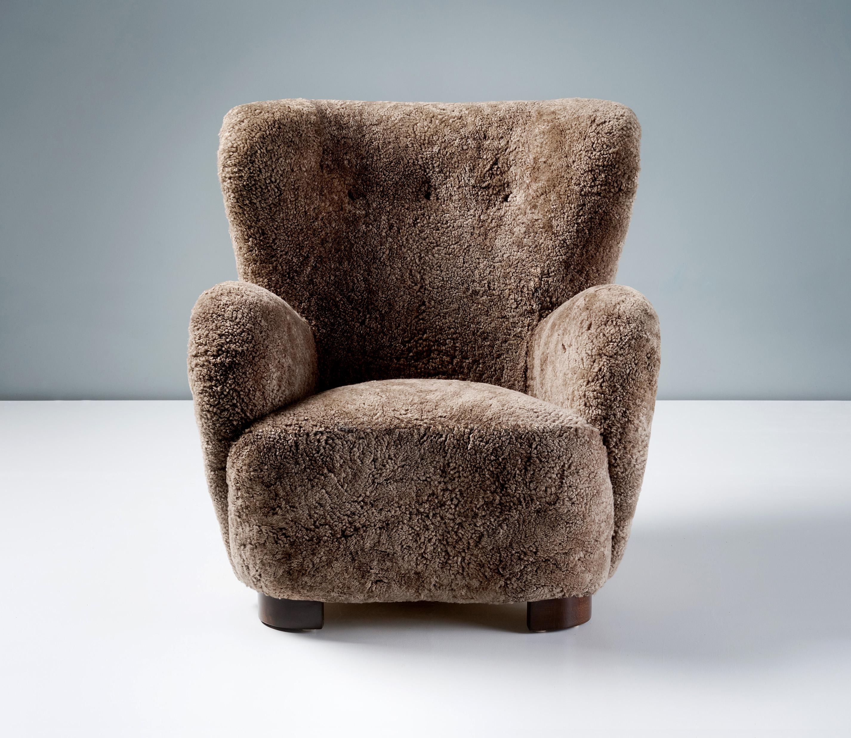Danish Cabinetmaker Sheepskin Armchair, circa 1940s.

This large lounge chair produced by a Danish Cabinetmaker in the 1940s is typical of Danish lounge chair designs of the day. It features large, curved arms and low, wide, refinished stained beech