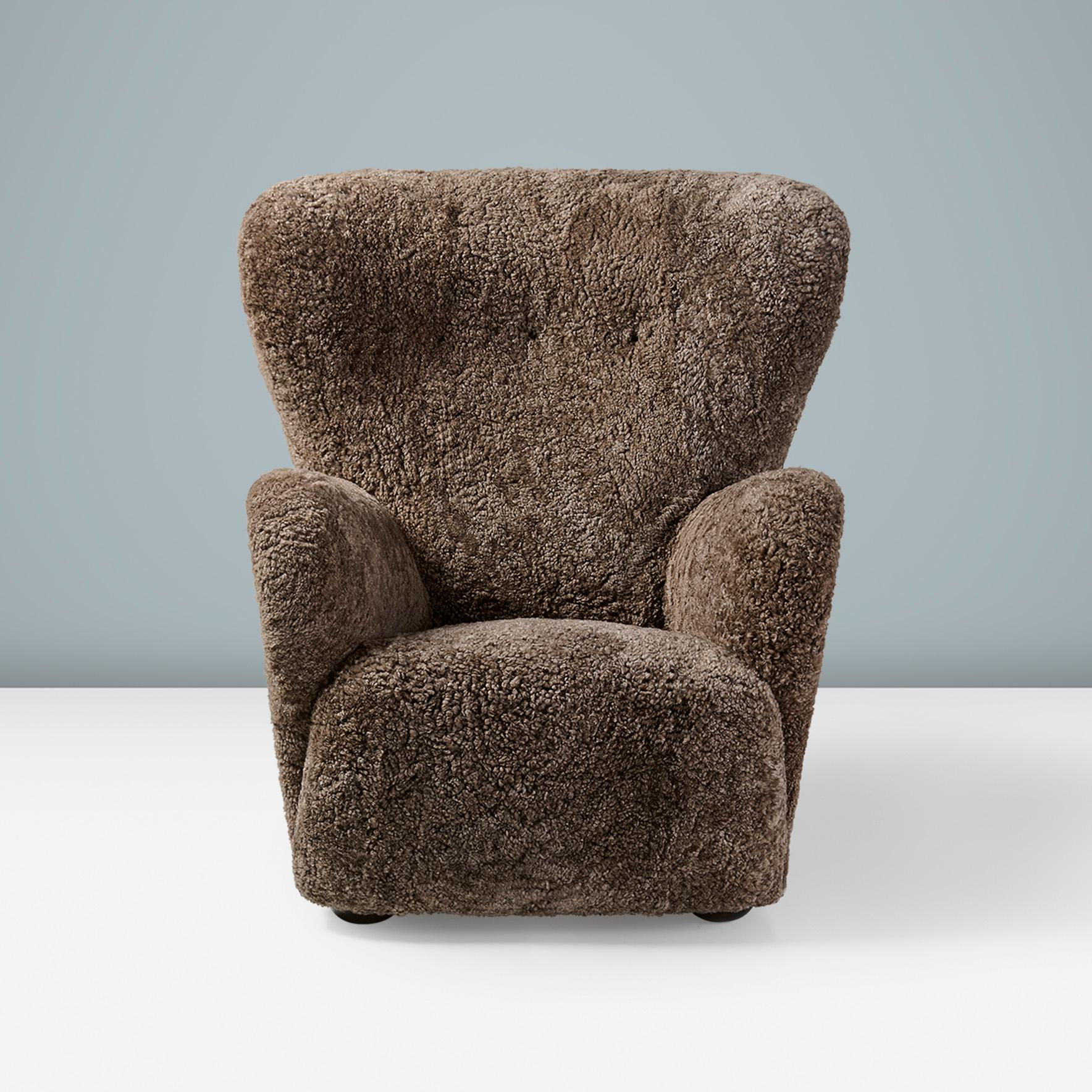 Danish Cabinetmaker Sheepskin Armchair, circa 1940s.

This large wing chair produced by a Danish Cabinetmaker in the 1940s is typical of Danish upholstered furniture of this period, featuring exaggerated curves in the arms and back, a deep, wide