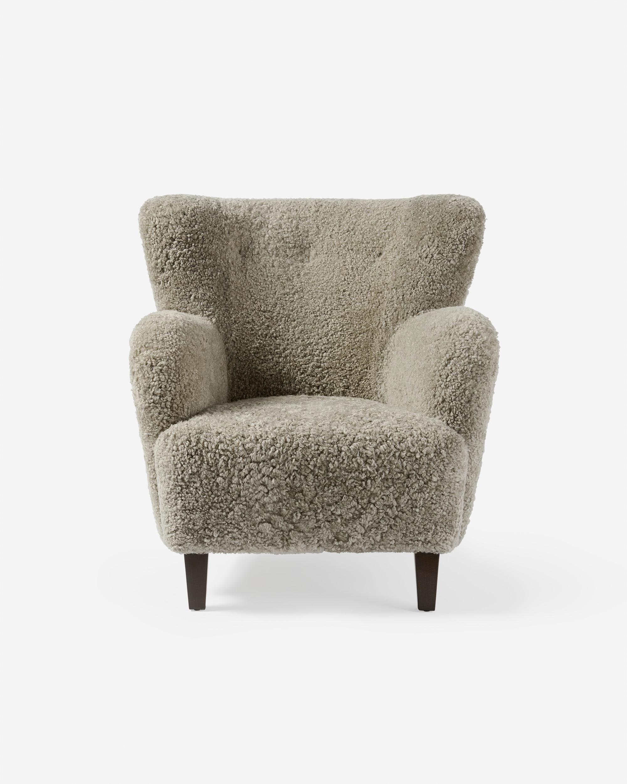 Danish Cabinetmaker Sheepskin Armchair, circa 1940s.

This Lounge chair produced by a Danish Cabinetmaker in the 1940s and is typical of Danish lounge chair designs of the day. It features a curved wing-back with stained beech legs. The chair has