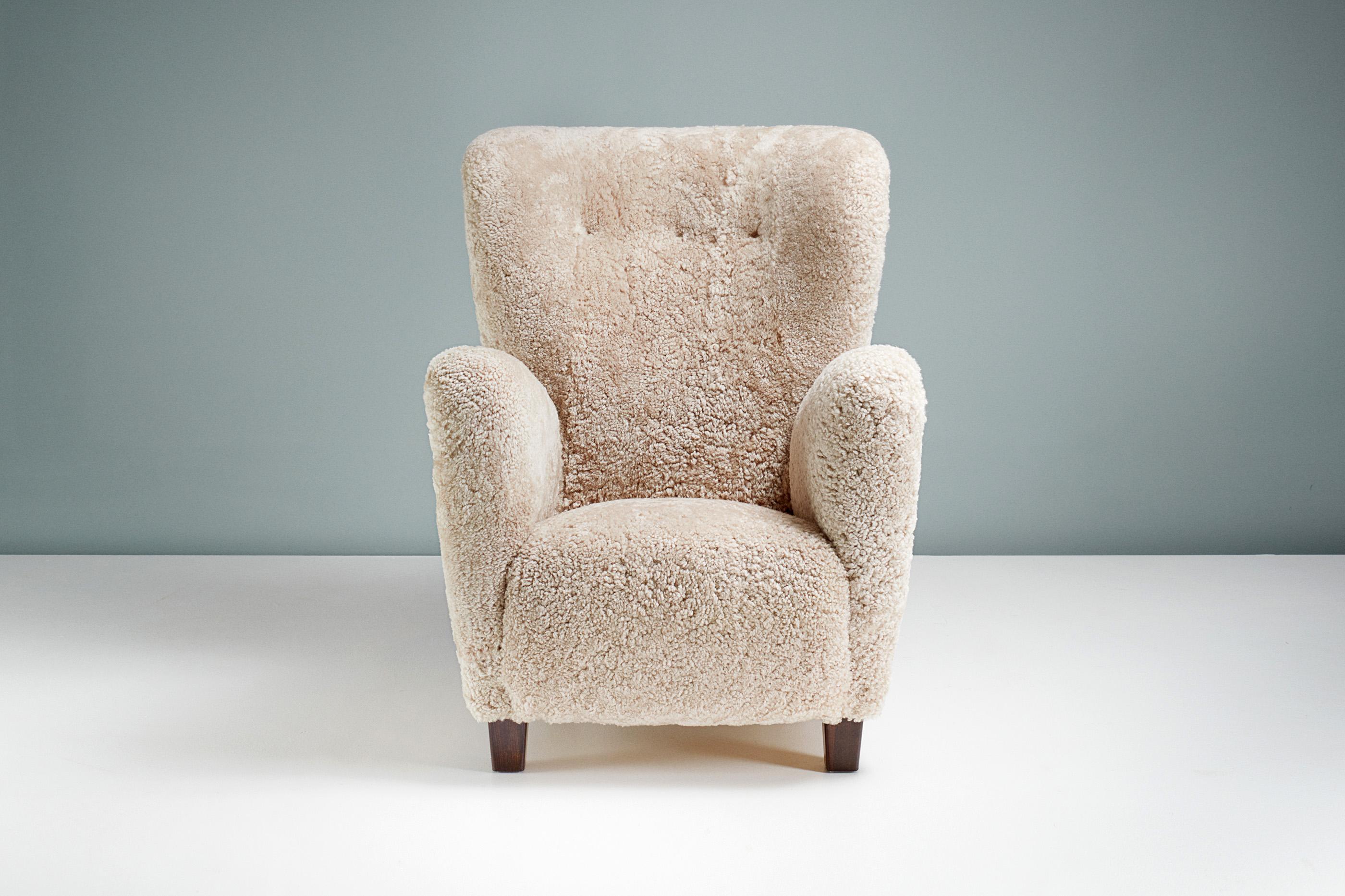 Fauteuil en peau de mouton d'ébéniste danois, vers 1940.

Chaise longue à haut dossier fabriquée par un ébéniste danois dans les années 1940. Il est doté d'un dossier à oreilles incurvé et de pieds en hêtre teinté. La chaise a été entièrement remise