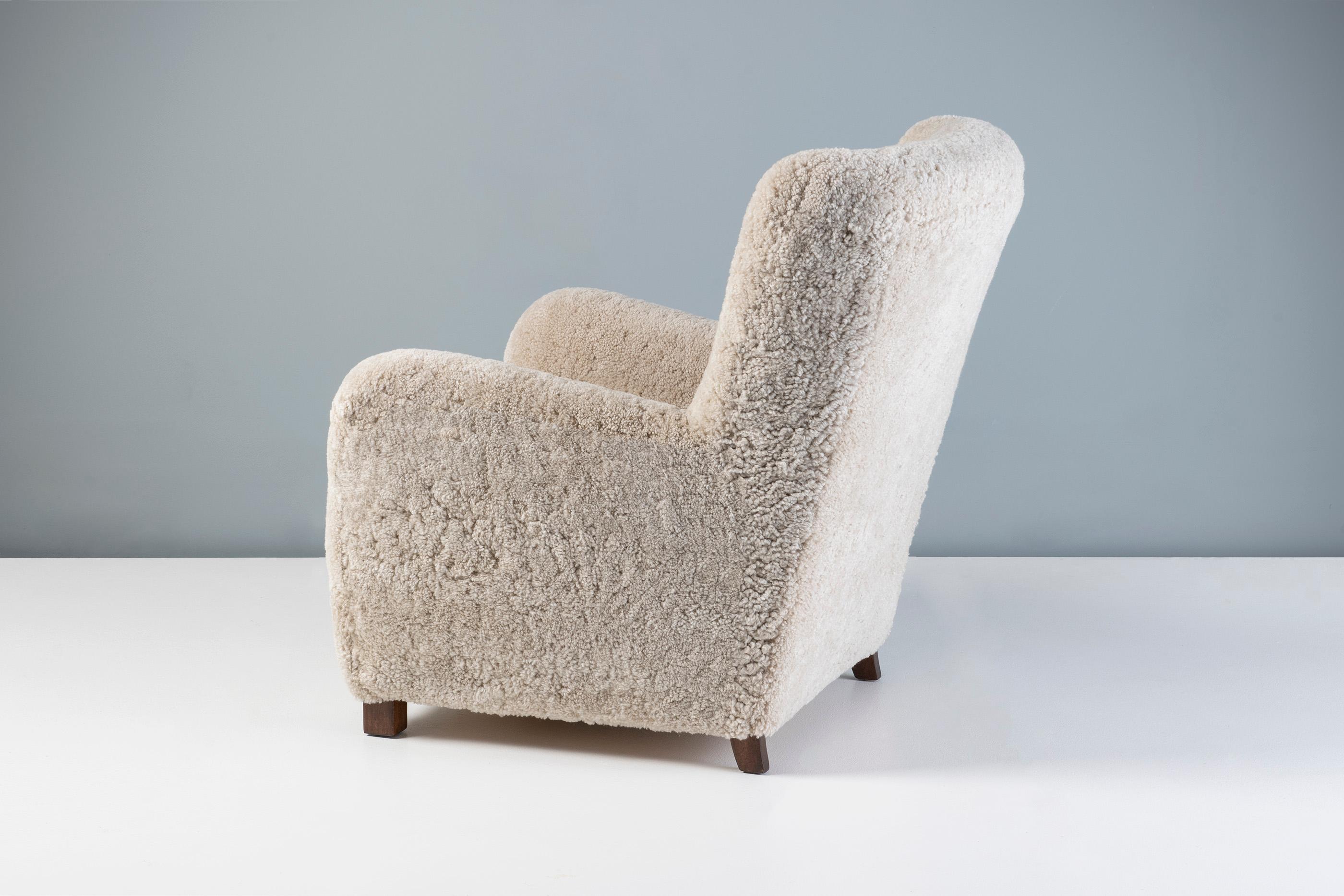 Danish Cabinetmaker Sheepskin Armchair, circa 1940s.

This tall Lounge chair produced by a Danish Cabinetmaker in the 1940s and is typical of Danish lounge chair designs of the day. It features a curved wing-back with stained beech legs. The chair