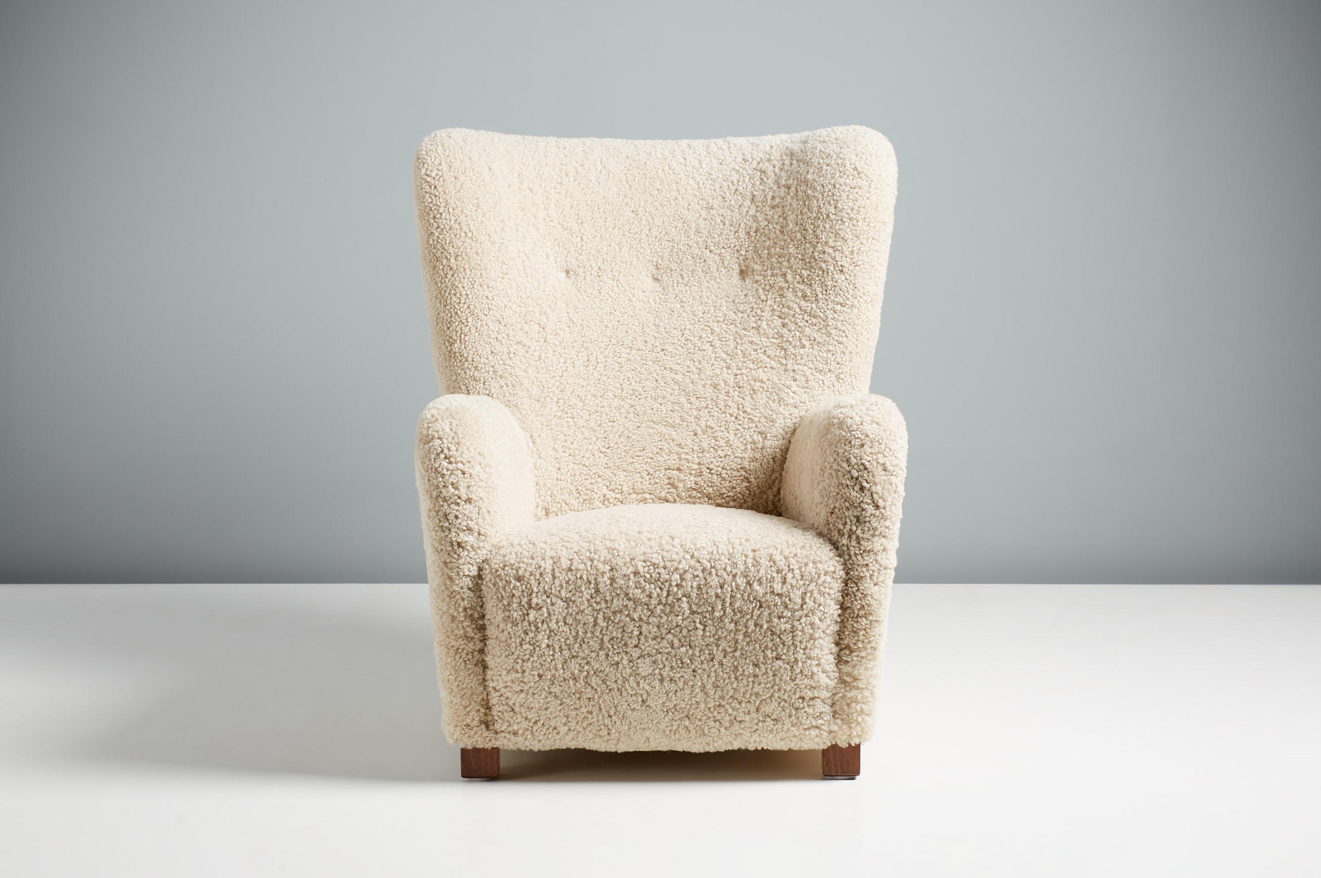 Danish Cabinetmaker Sheepskin Armchair, circa 1940s.

This tall Lounge chair produced by a Danish Cabinetmaker in the 1940s and is typical of Danish lounge chair designs of the day. It features a curved wing-back with stained beech legs. The chair