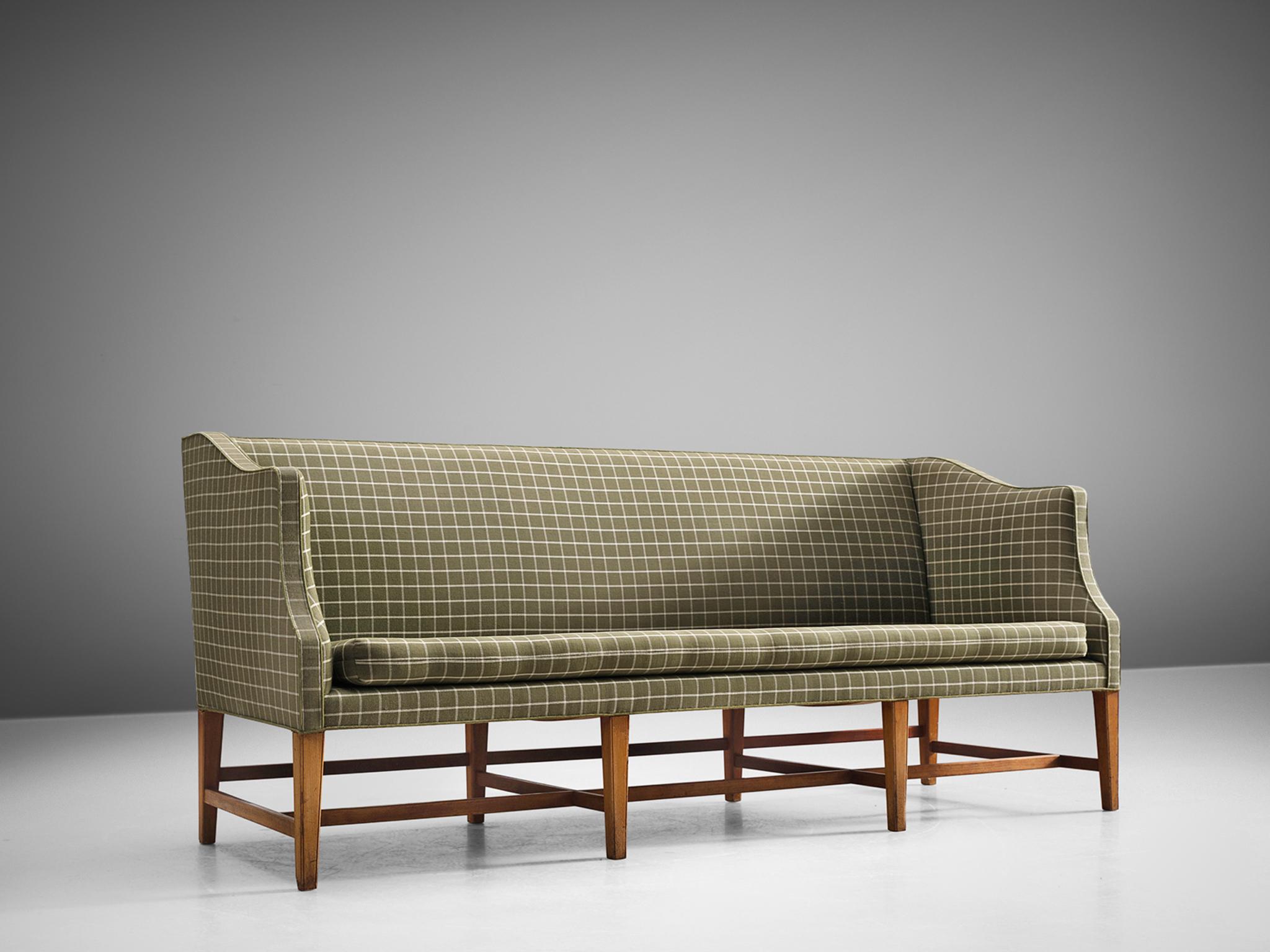 Danish cabinetmaker, fabric, teak, Denmark, 1950s. 

Free-standing three-seat sofa with eight profiled teak legs. The sofa is upholstered with a white and green checked fabric. The sofa features ornate forms and shapes and holds a geometric, rigid