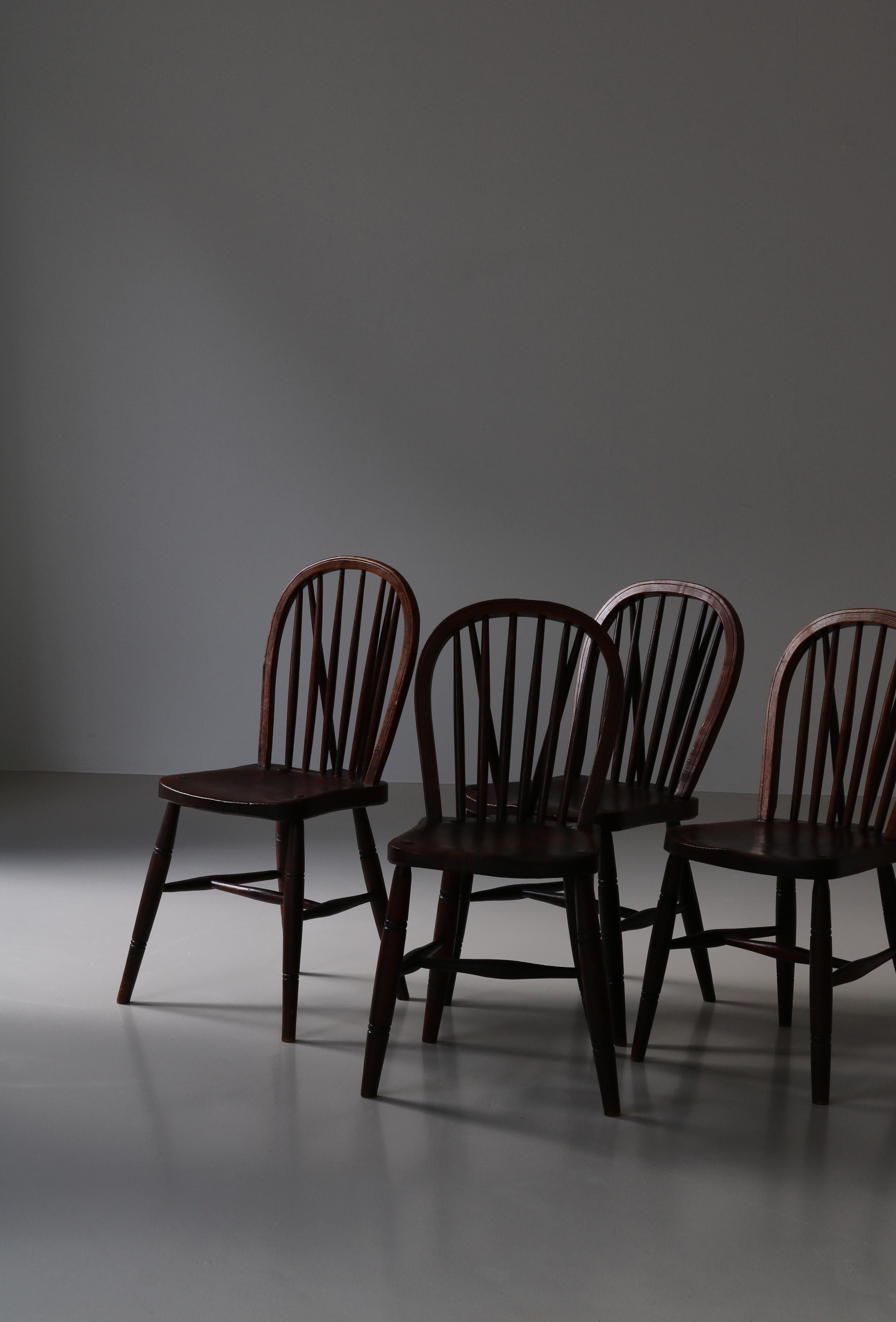 Ensemble de 4 charmantes chaises à dossier en fuseau de style art populaire fabriquées au Danemark au début du 20e siècle par un ébéniste. Les chaises sont fabriquées en bois d'orme massif teinté, avec un grain et une patine étonnants. La qualité de