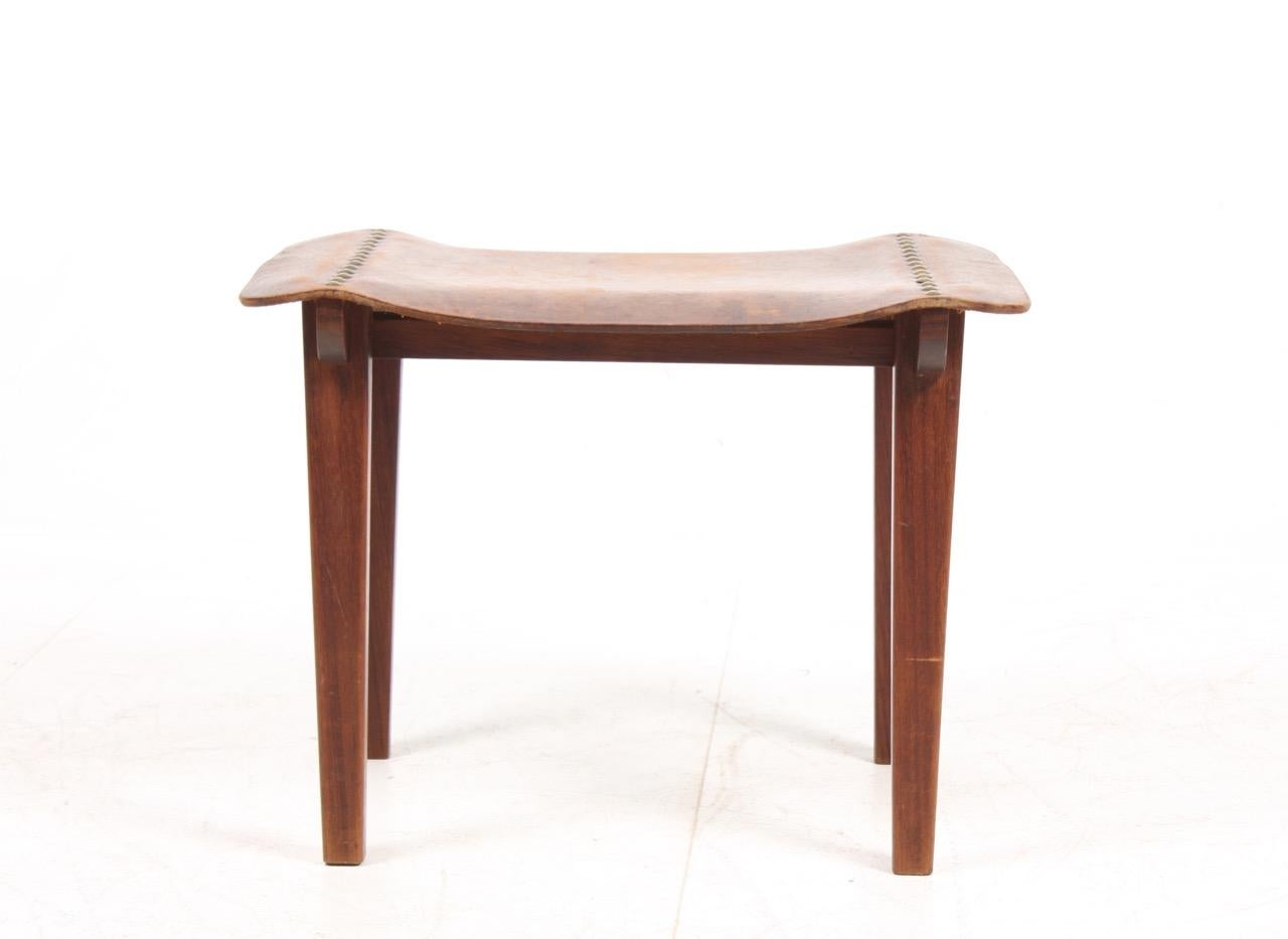 Stool in solid teak and seat in patinated leather. Made by Danish cabinetmaker in the 1940s.