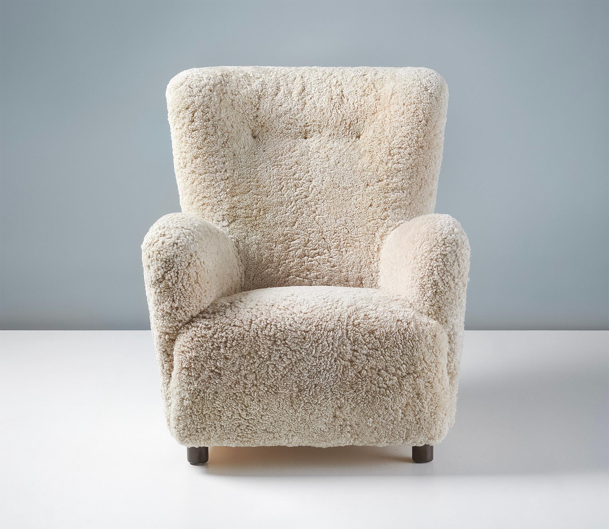 Danish Cabinetmaker Sheepskin Armchair, circa 1940s.

This tall lounge chair produced by a Danish Cabinetmaker in the 1940s is typical of Danish lounge chair designs of the day. It features a slightly curved wing-back with large round arms and