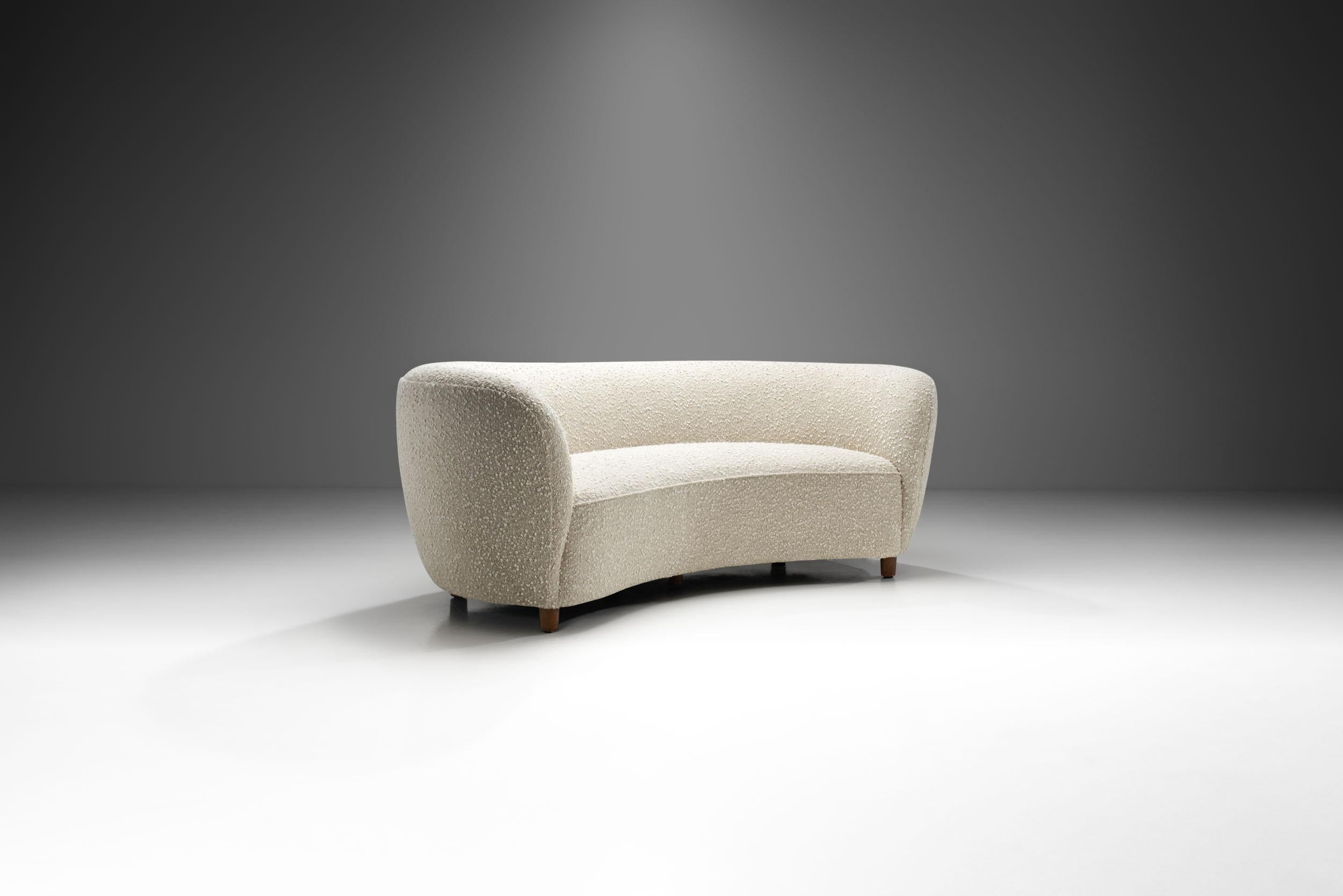 Dieses schöne dänische Dreisitzer-Sofa erinnert an den Art-Déco-Stil der 1930er Jahre mit dem erkennbaren Touch des dänischen Modernismus. Dank seiner elegant geschwungenen Form wird dieser Sofatyp oft als 