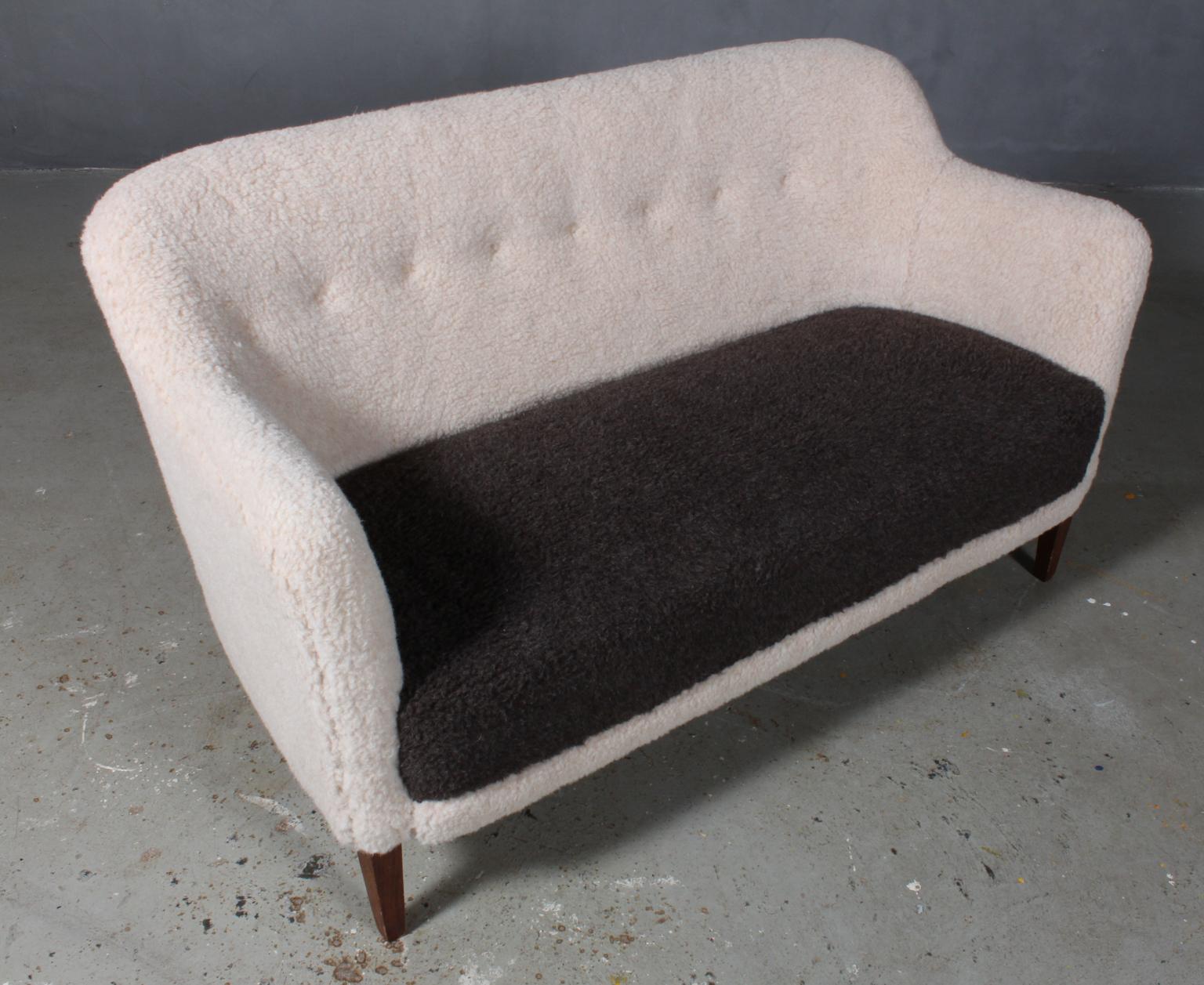 Danish cabinetmaker two-seat sofa new upholstered with two-tone lambwool.

Legs of stained oak

Made in the 1940s.