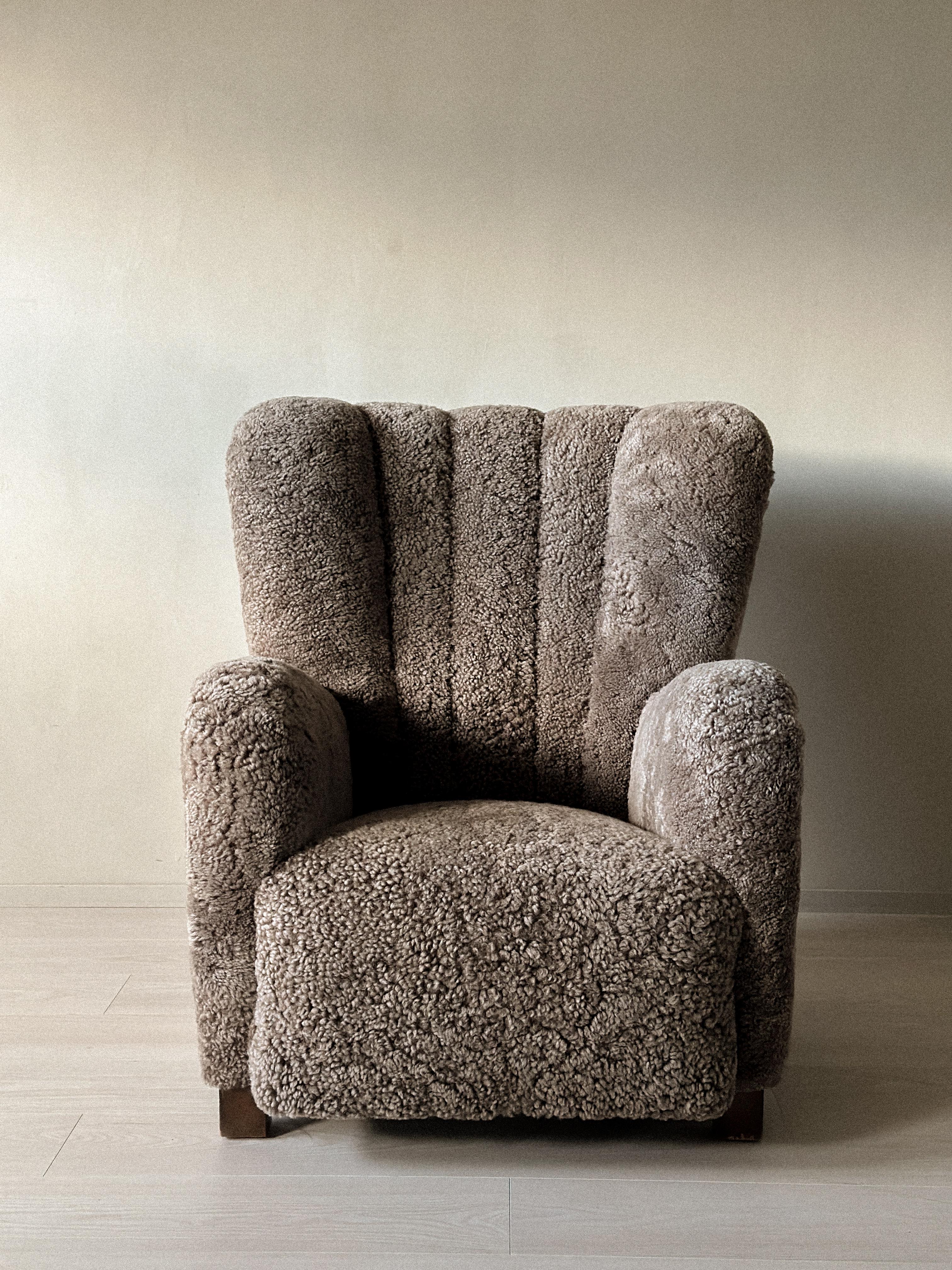 A 1940s Danish Cabinetmaker wing back lounge chair with beautiful curves. The chair is newly reupholstered in premium shearling.