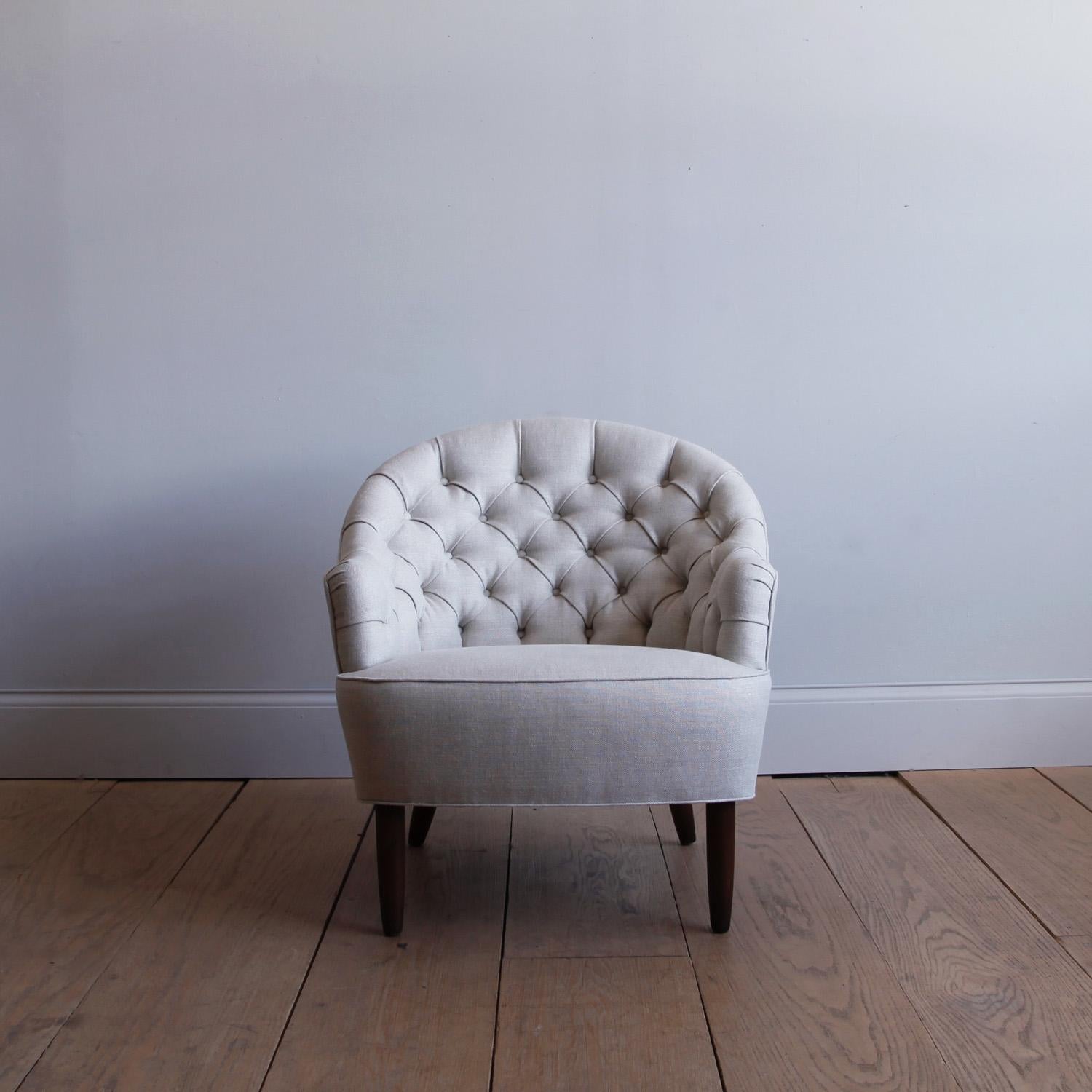 A petite and handsome lounge chair with barrel back, recently recovered in Belgian linen.
  