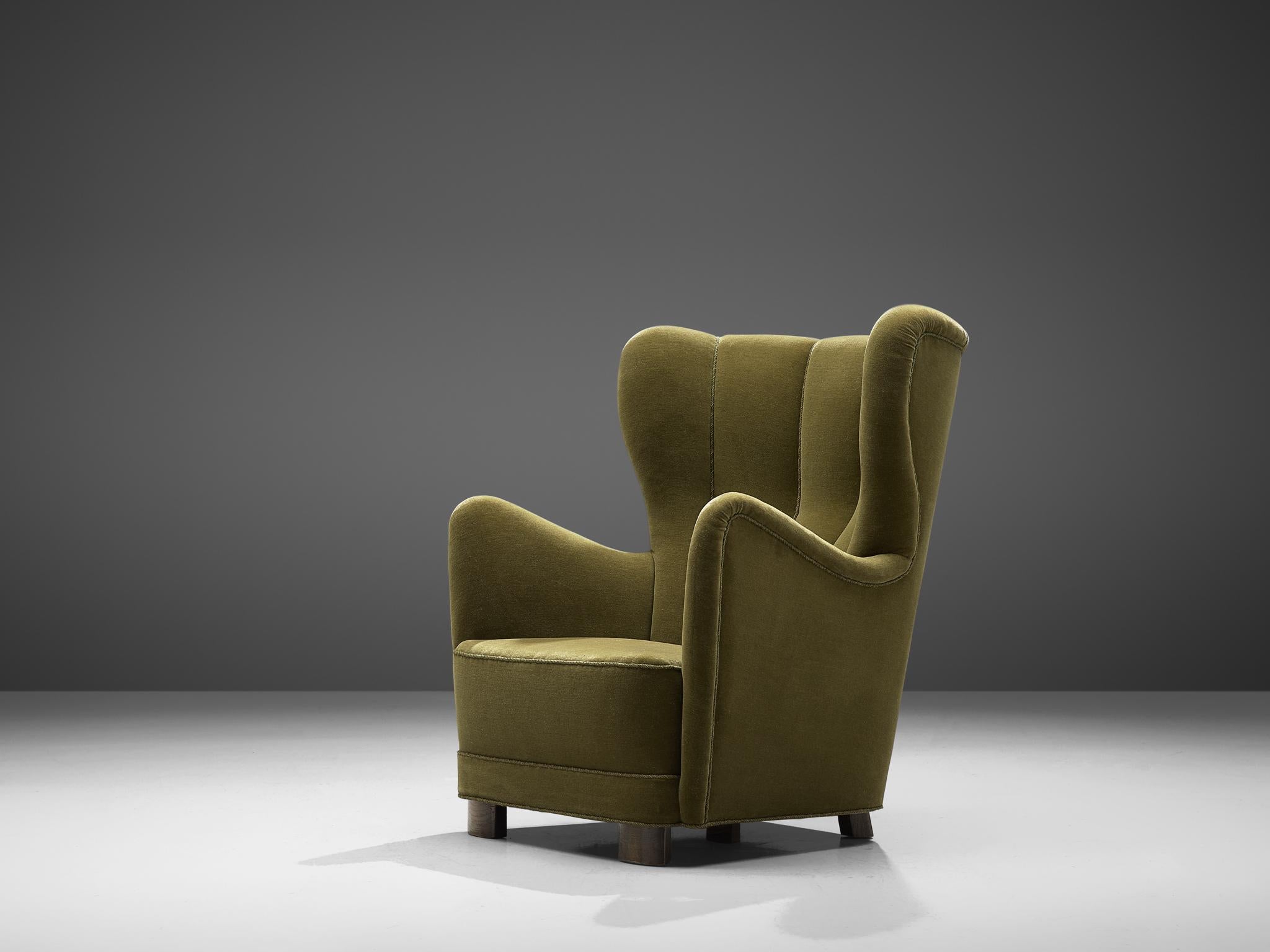 Lounge chair, beech legs and green fabric, Denmark, 1940s

This stately easy chair with high back that originates from the 1940s, is the predecessor of what came to be known as modern Danish design that it is today, featuring organic forms and