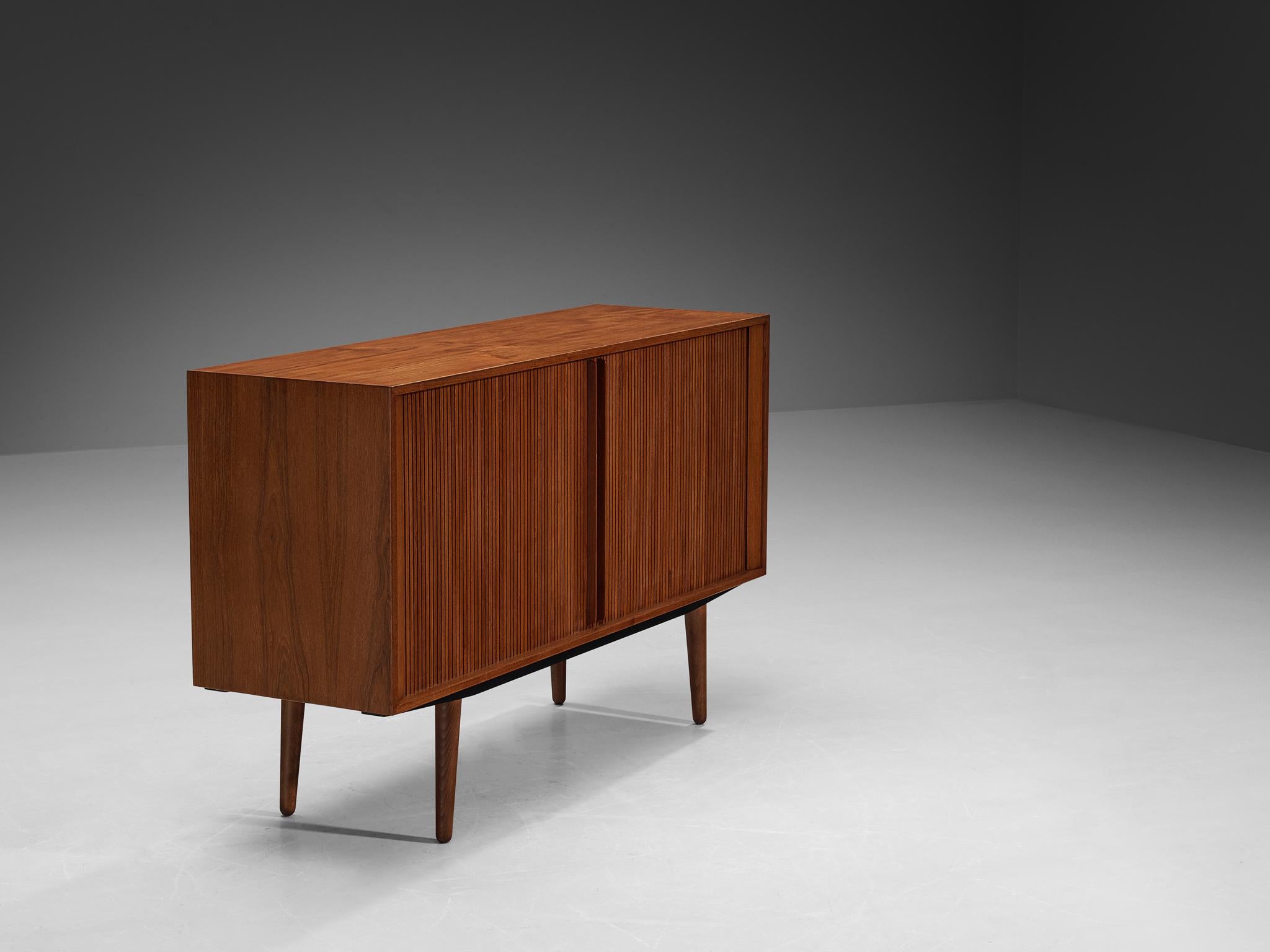 Cabinet, teak, birch, felt, Denmark, 1950s

This sideboard is exemplary for refined, highly detailed and very well-made furniture. The front corpus is furnished with tambour door panels that easily move sideways. The extended doorhandles and beveled