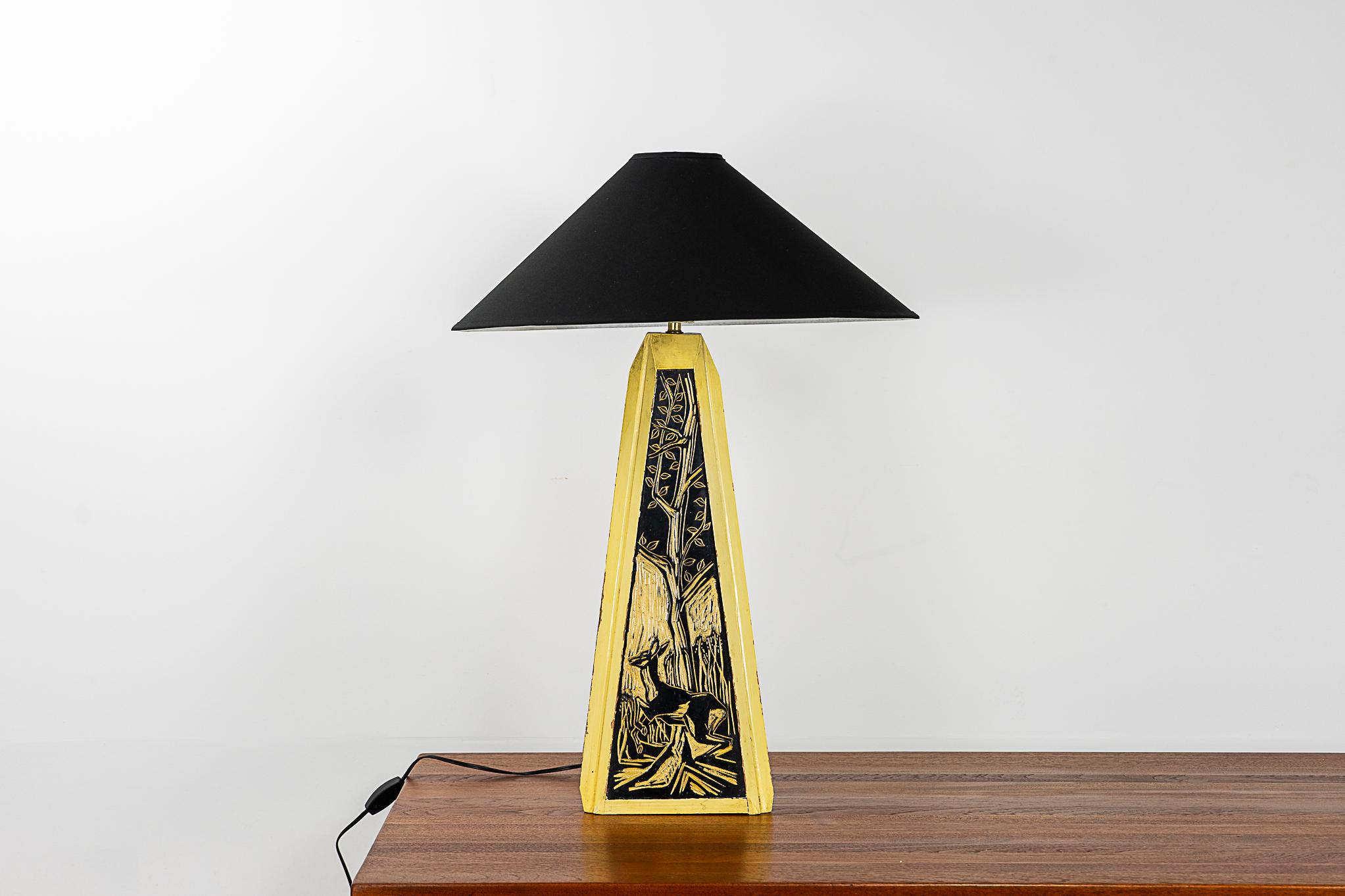 Carved wood Danish table lamp, circa 1960's. Incredibly unique lamp, yellow and black intaglio design of a deer in the woods on each. Custom fabric shade and new wiring with inline switch. A statement lamp for sure! 

Please inquire for