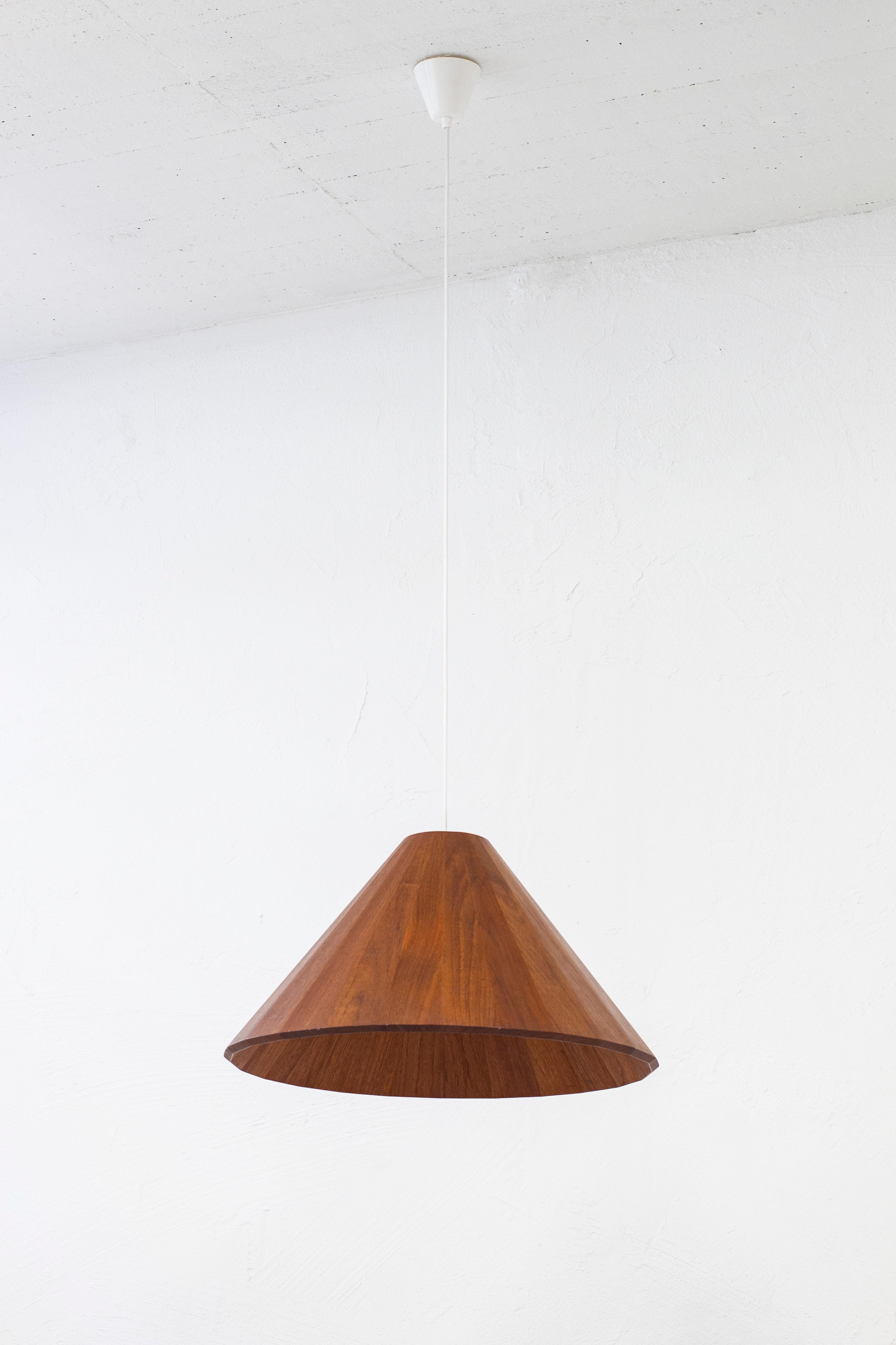 Ceiling lamp made in Denmark. Made from thick solid staved teak. Most likely made by a skilled cabinet maker and likely unique. Done somewhere around the 1950s. Custom made brass fitting and porcelain lamp fitment. Very good vintage condition with