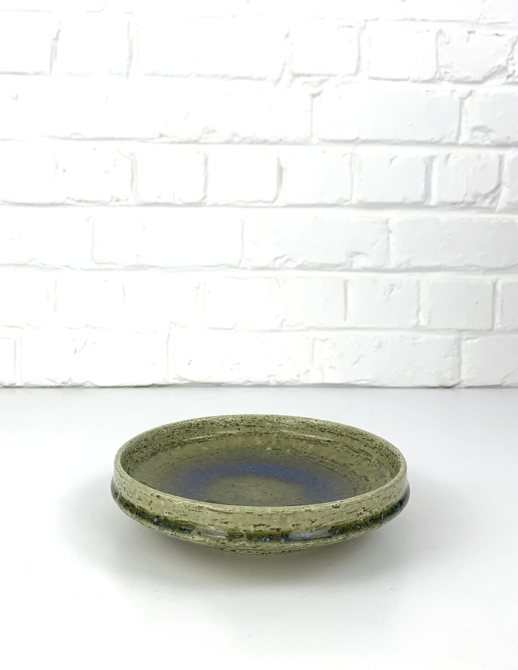 Ceramic vide-poche or low bowl in olive green tones with a subtle blue flame in the center. It comes with a thick glaze.

Scandinavian Mid-Century 1960s, produced by Palshus (Denmark), founded by Per and his wife Annelise Linnemann-Schmidt. 

The