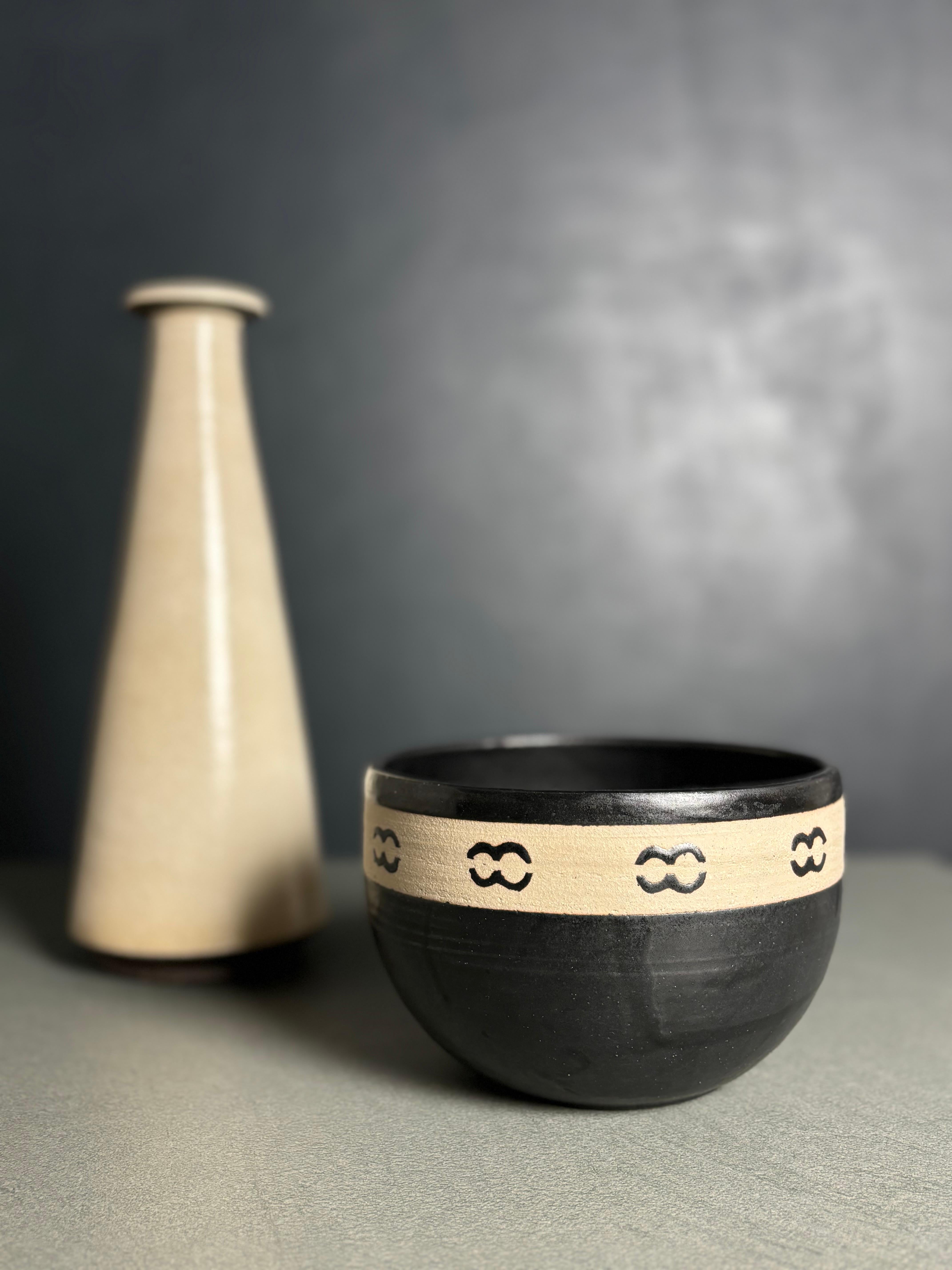 Ciotola decorativa danese in ceramica moderna con smalto marrone scuro e motivo grafico dipinto a mano lungo la parte superiore non smaltata. Firmato e datato sotto la base.
Bellissime condizioni vintage. 
Danimarca, 2002.