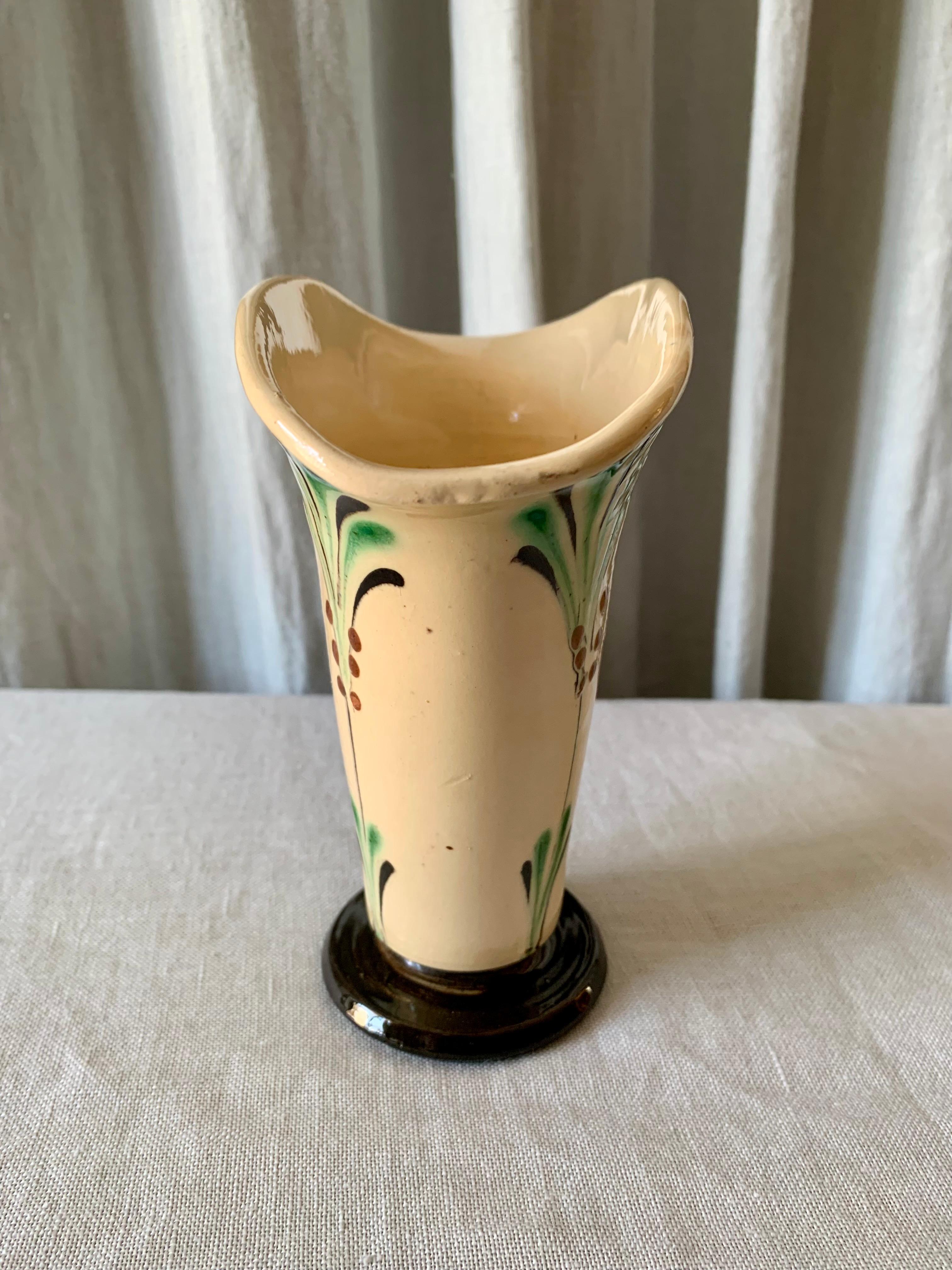 Danish 1930s ceramic vase by Kähler with a flattend shape which makes the bouquet of flowers unfold in a beautiful way. It is a vase shape that is very characteristic of the 1930s and very Art Deco. The vase has a very small chip on the upper rim -