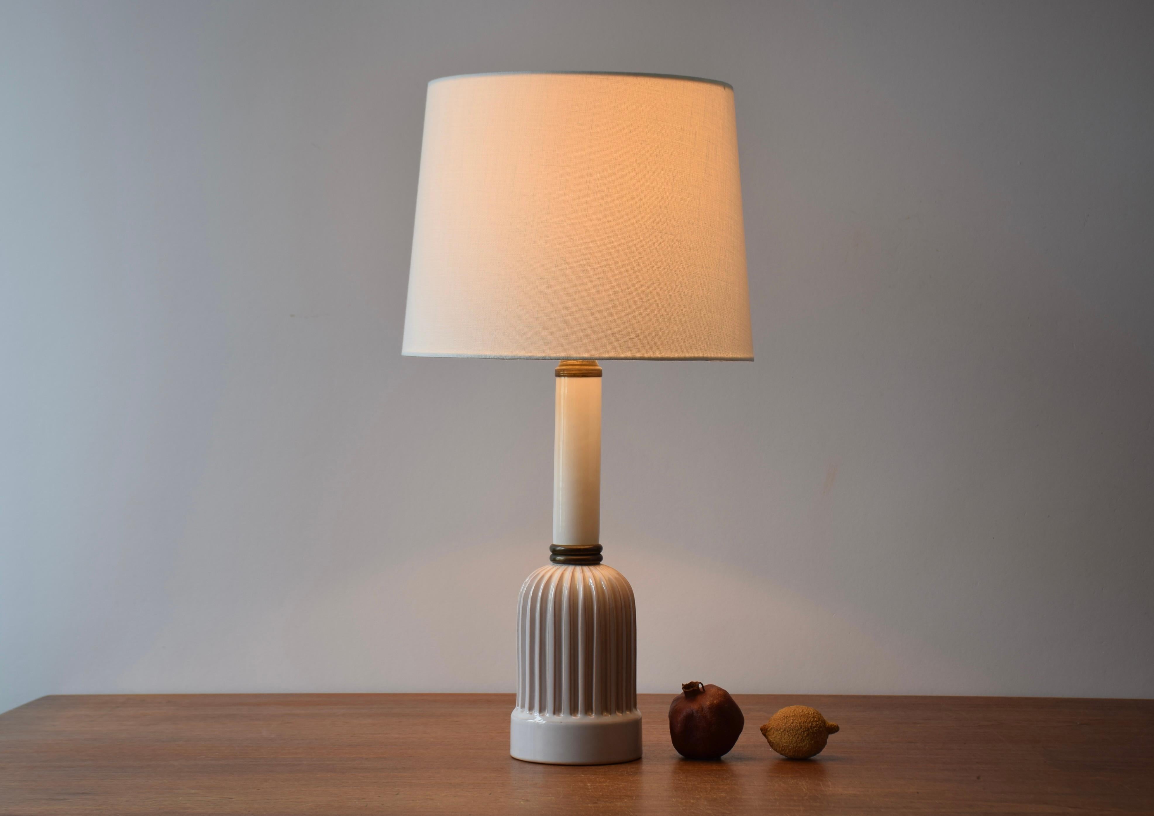 Dänische Vintage-Keramik-Tischlampe mit dekorativem gerilltem Korpus. Hergestellt ca. 1950s.

Die Lampe ist unsigniert, aber sie könnte entweder aus der Keramikwerkstatt Schollert oder Eslau stammen oder im Stil dieser Werkstätten gestaltet sein. Er