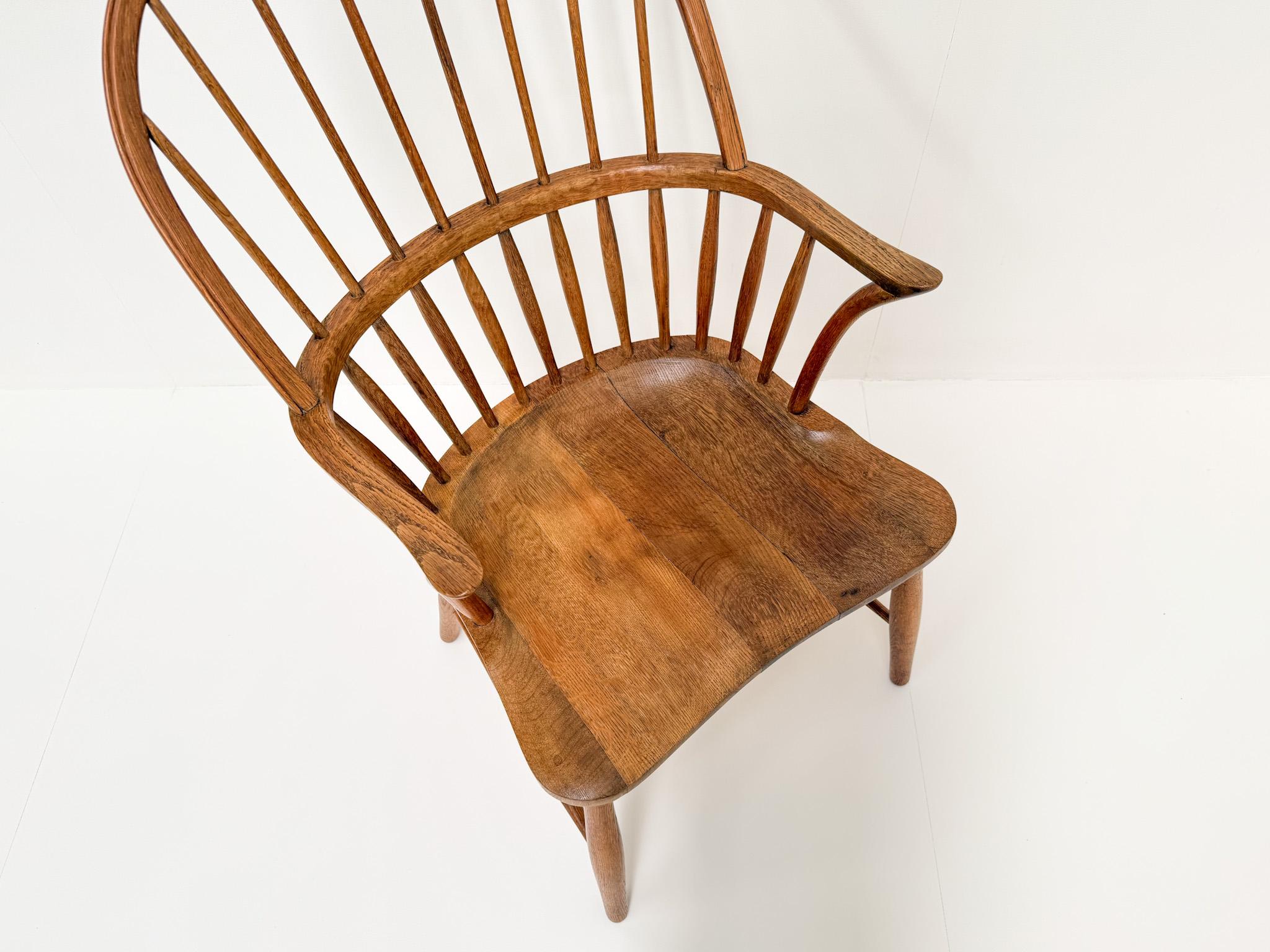 Bellissima poltrona danese con schienale alto disegnata da Frits Henningsen e prodotta da Carl Hansen & Søn negli anni '60. Questo modello, CH18A, è realizzato in rovere massiccio e presenta uno schienale scultoreo a fuso, braccioli curvi e una