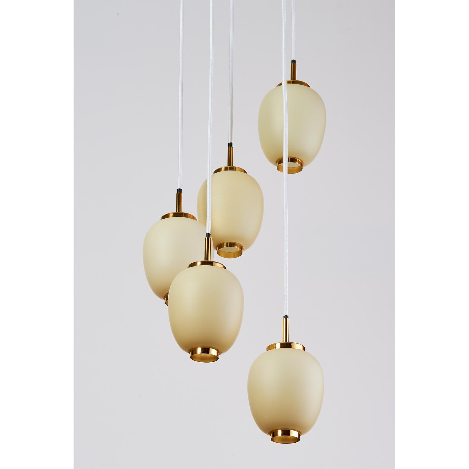 Denmark, 1960s.
Pendant chandelier with five adjustable oval glass opaline shades mounted on polished brass mounts
Suspended on white fabric cord
Dimensions: 50 H x 12 Diameter
Rewired for use in the USA.